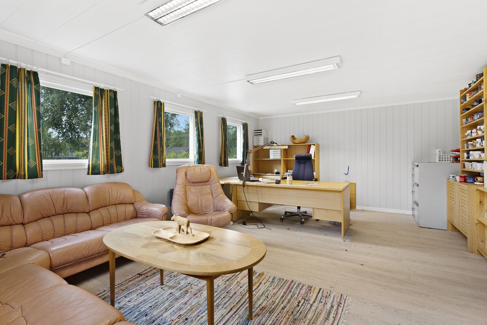 Kontoret i garasjen har laminatgulv og MDF-plater. Galleribilde