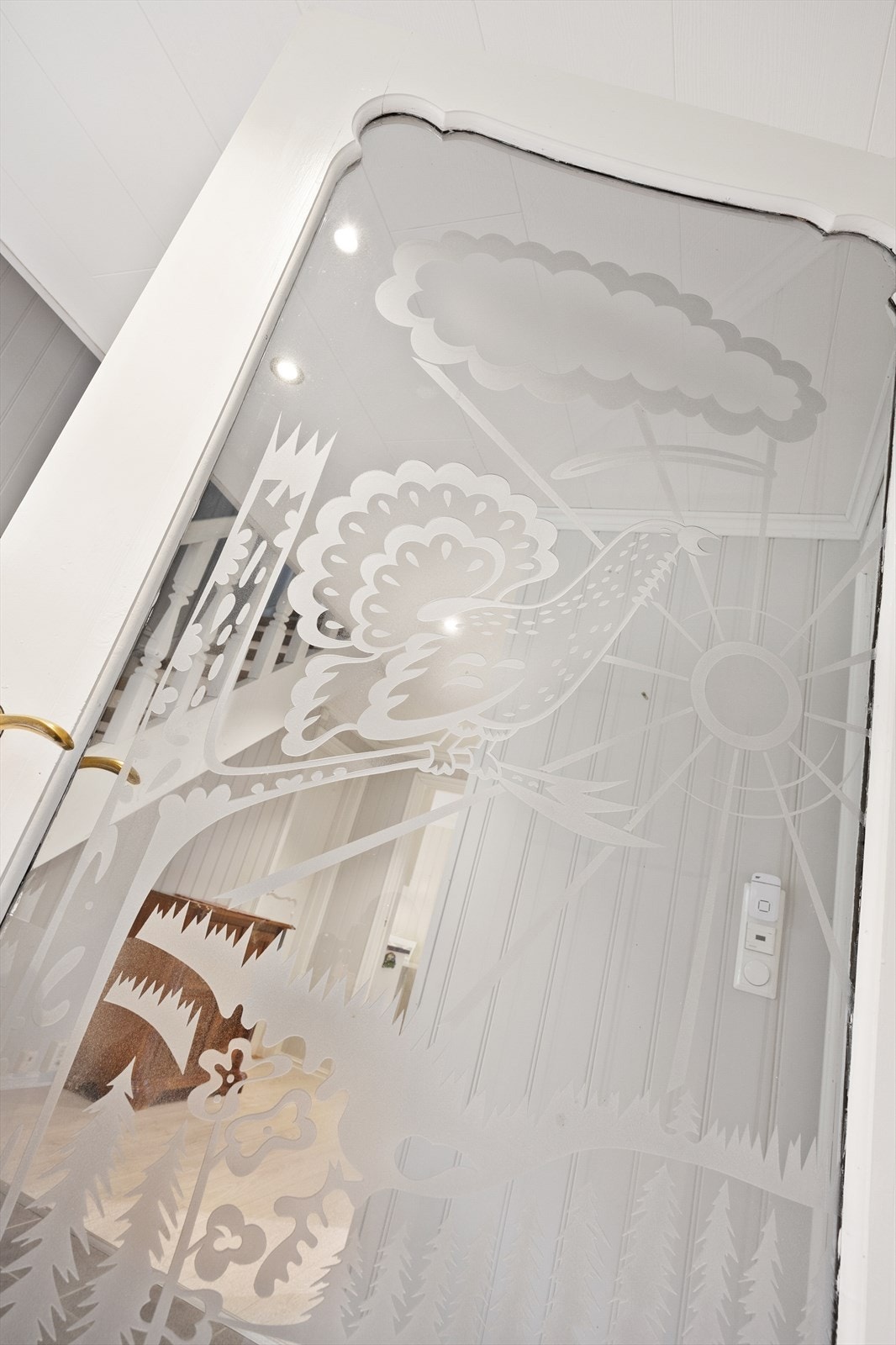 En detaljrik glassdør skiller yttergang fra hallen Galleribilde