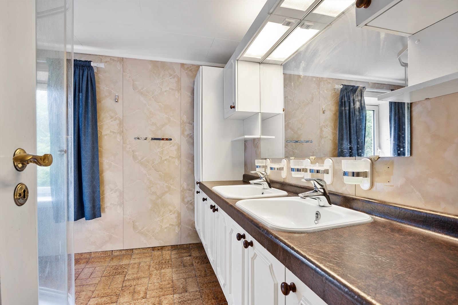 Innredningen har mye skapplass og to servanter nedfelt i benkeplaten - over er det speil med belysning. Galleribilde