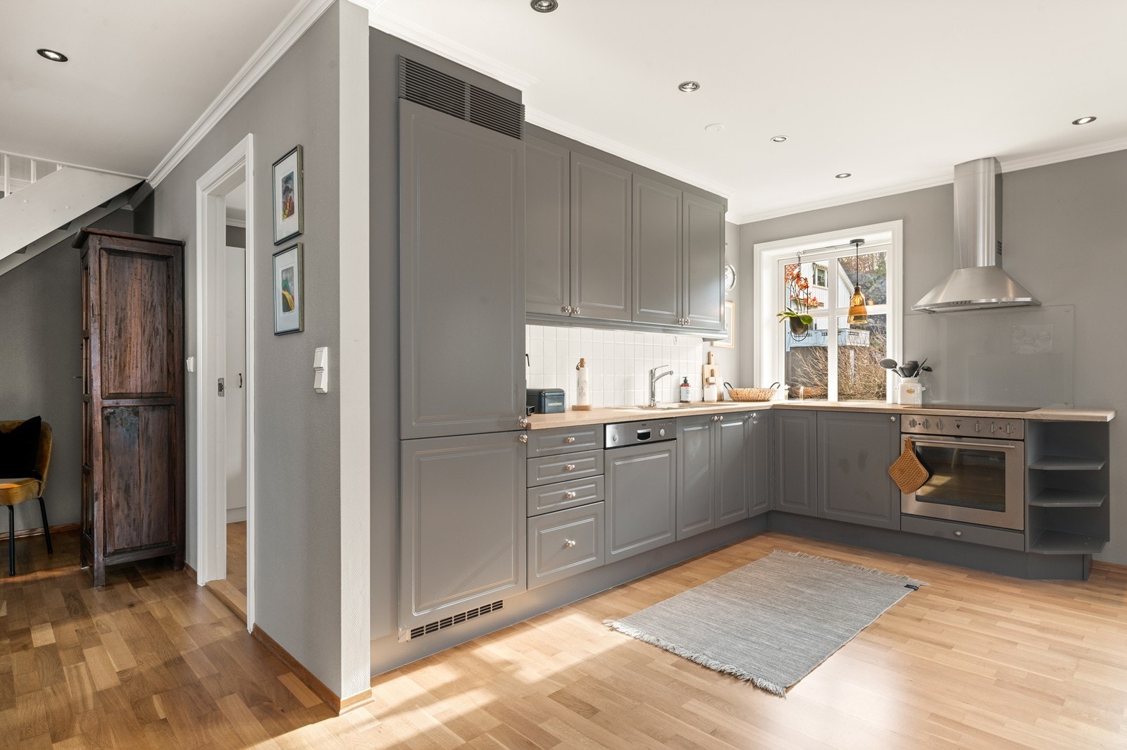 Kjøkkenet har innredning med profilerte fronter og laminat benkeplate. Det er integrert oppvaskmaskin, komfyr, platetopp og kombiskap Galleribilde