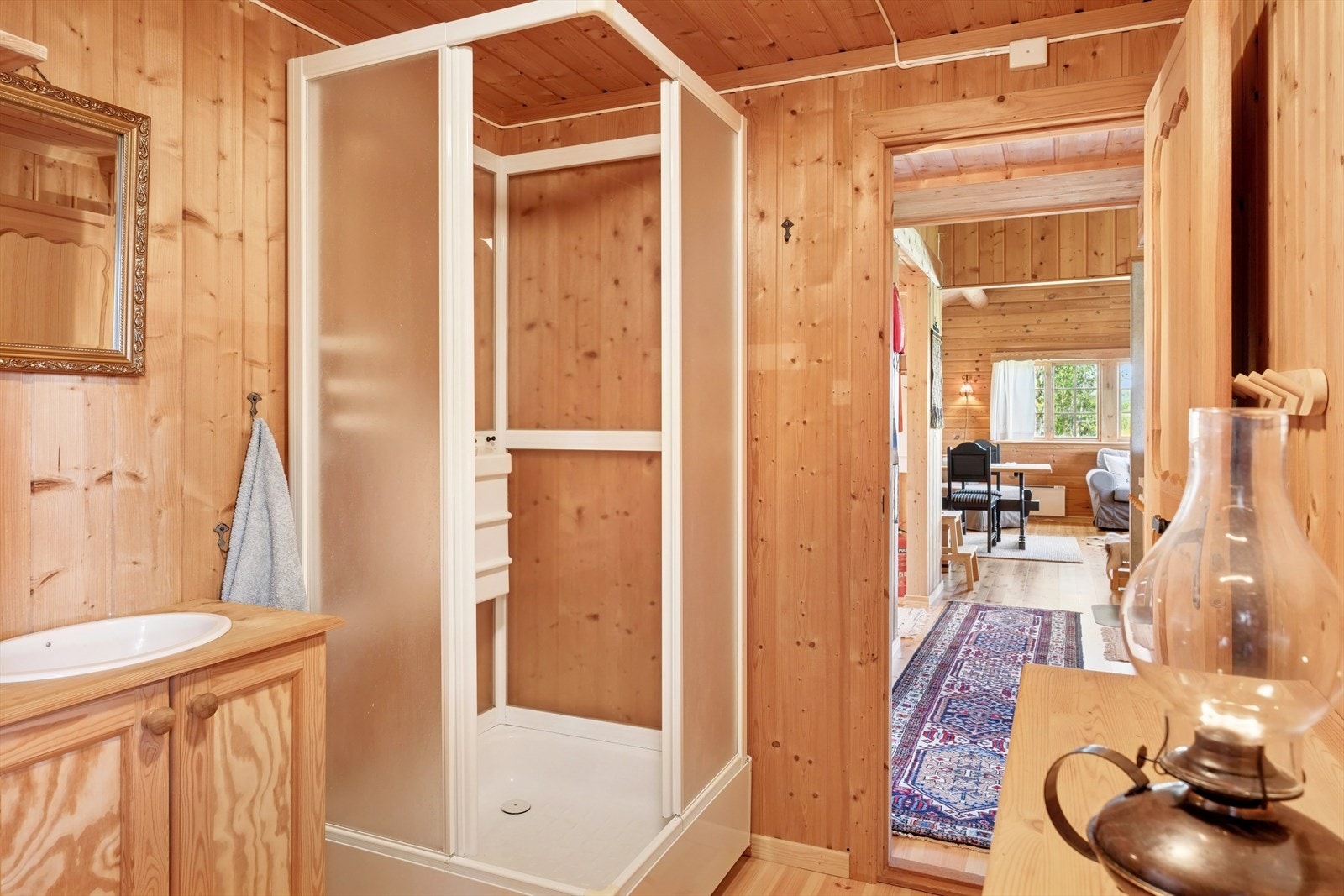 I andre enden fra stuen har du et praktisk vaskerom med frittstående dusjkabinett og utslagsservant. Galleribilde