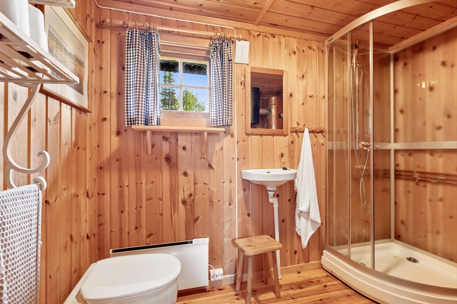 Vaskerom med frittstående dusjkabinett, vegghengt utslagsvask og snurrdass. Galleribilde