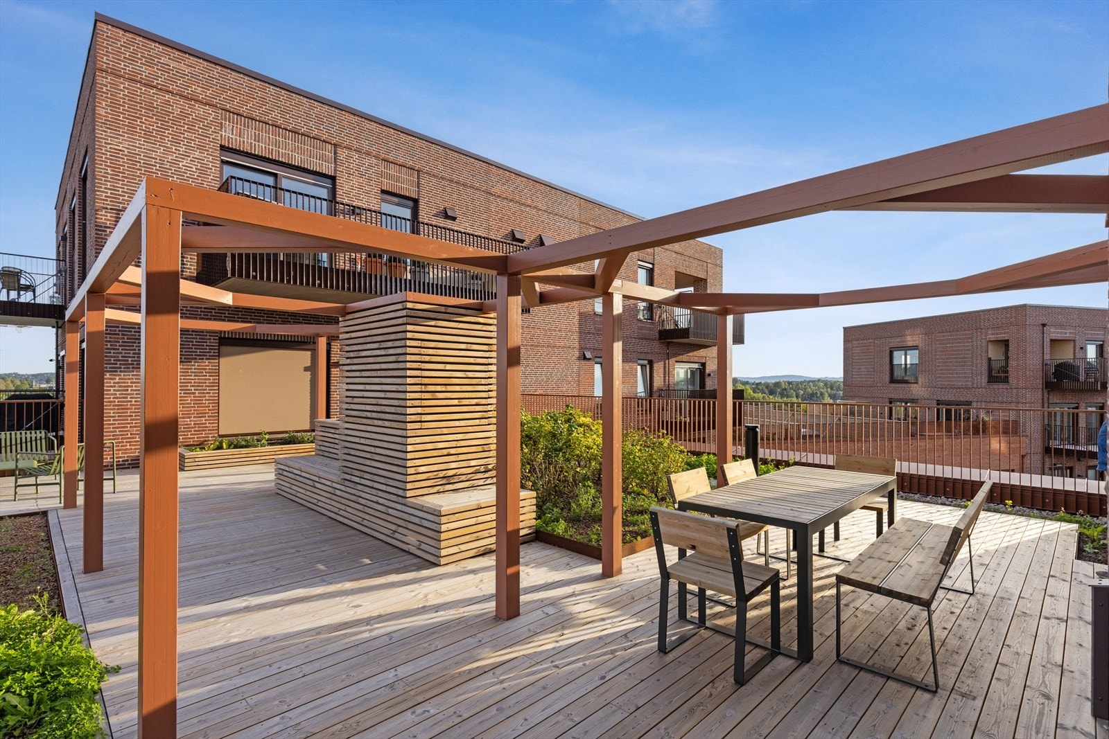 Heis direkte opp til stor felles takterrasse med utekjøkken, sittegrupper og sjøutsikt. Galleribilde