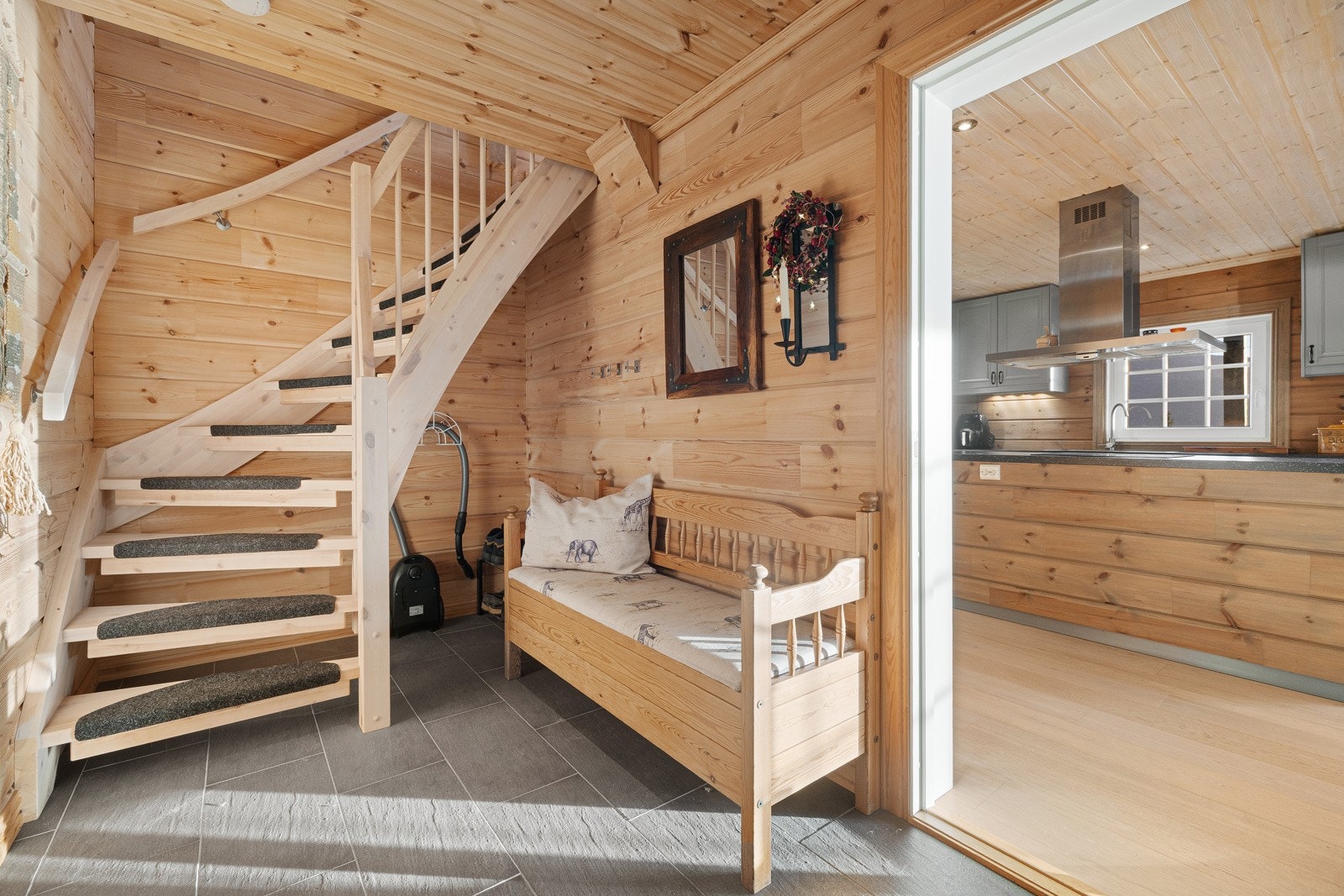 Entré med flislagt gulv, vegger og himling kledd med trepanel. Rommet fungerer som bindeledd mellom inngang, kjøkken/oppholdsrom og trapp til loftsetasje. God plass for garderobeløsninger. Galleribilde