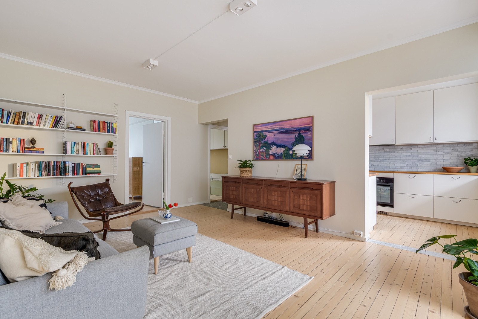 Kjøkkenet ligger i en fin delvis åpen løsning med stuen, naturlig tilbaketrukket, samtidig åpent og sosialt. Legg gjerne merke til marmordetaljen i gulvet i åpningen mellom stue og kjøkken. Galleribilde