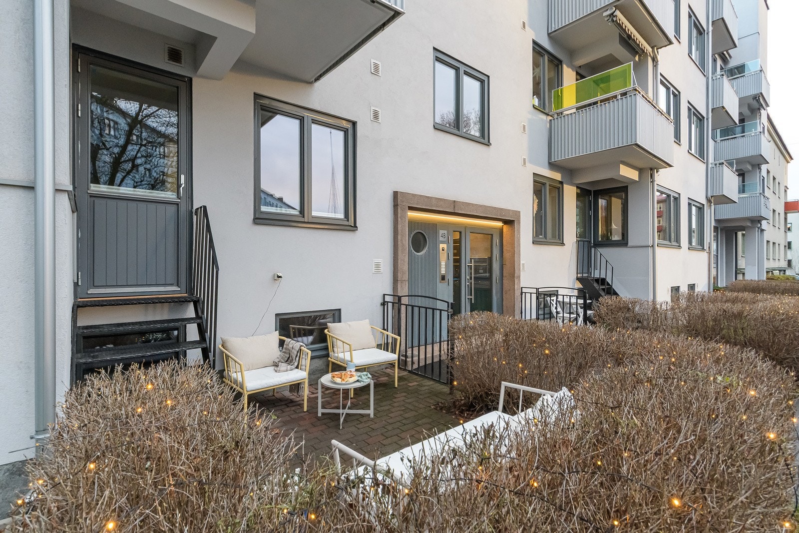 Uteplassen er pent belagt med belegningsstein, omkranset av en tett og frodig hekk som gir både skjerming og en lun, grønn atmosfære. Praktisk med stikkontakt montert under kjøkkenvinduet (gjort i 2019). Galleribilde