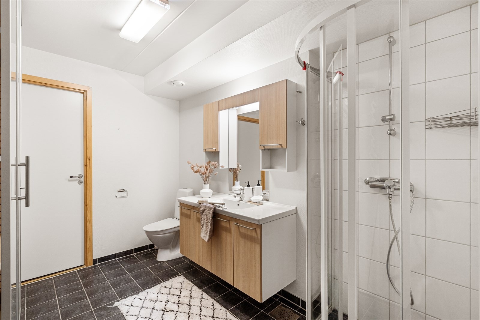 Lekkert flislagt bad med varmekabler i gulv og opplegg for vaskemaskin/tørketrommel. Galleribilde