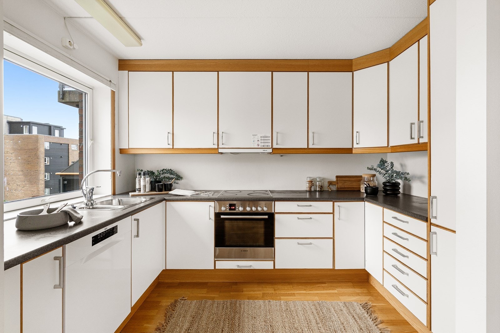 Flott kjøkken med hvitefronter og mørk benkeplate som skaper en fin helhet i utrykket. Galleribilde