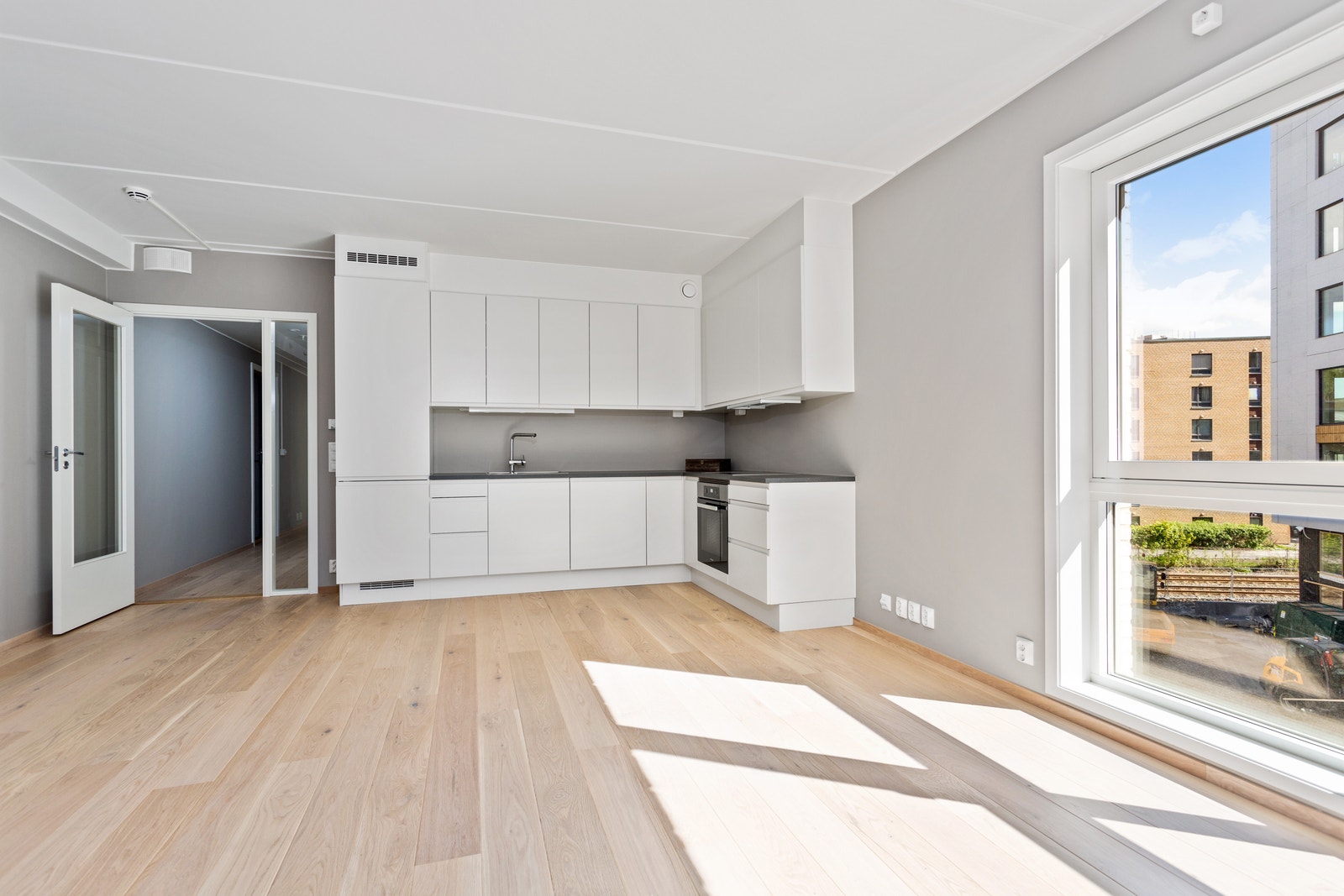 Åpen stue/kjøkkenløsning med plass for spisebord og sittegruppe. Galleribilde