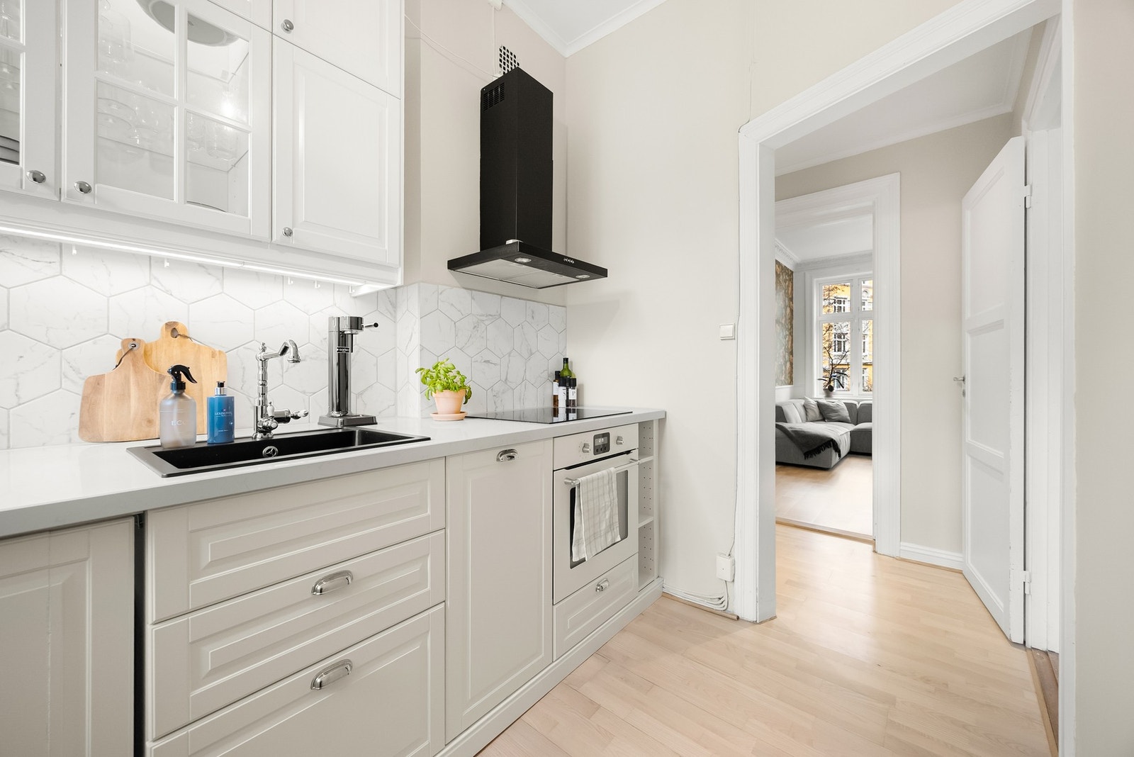 Kjøkkeninnredningen har profilerte fronter med noen vitrine fronter, samt benkeplate i stein Galleribilde