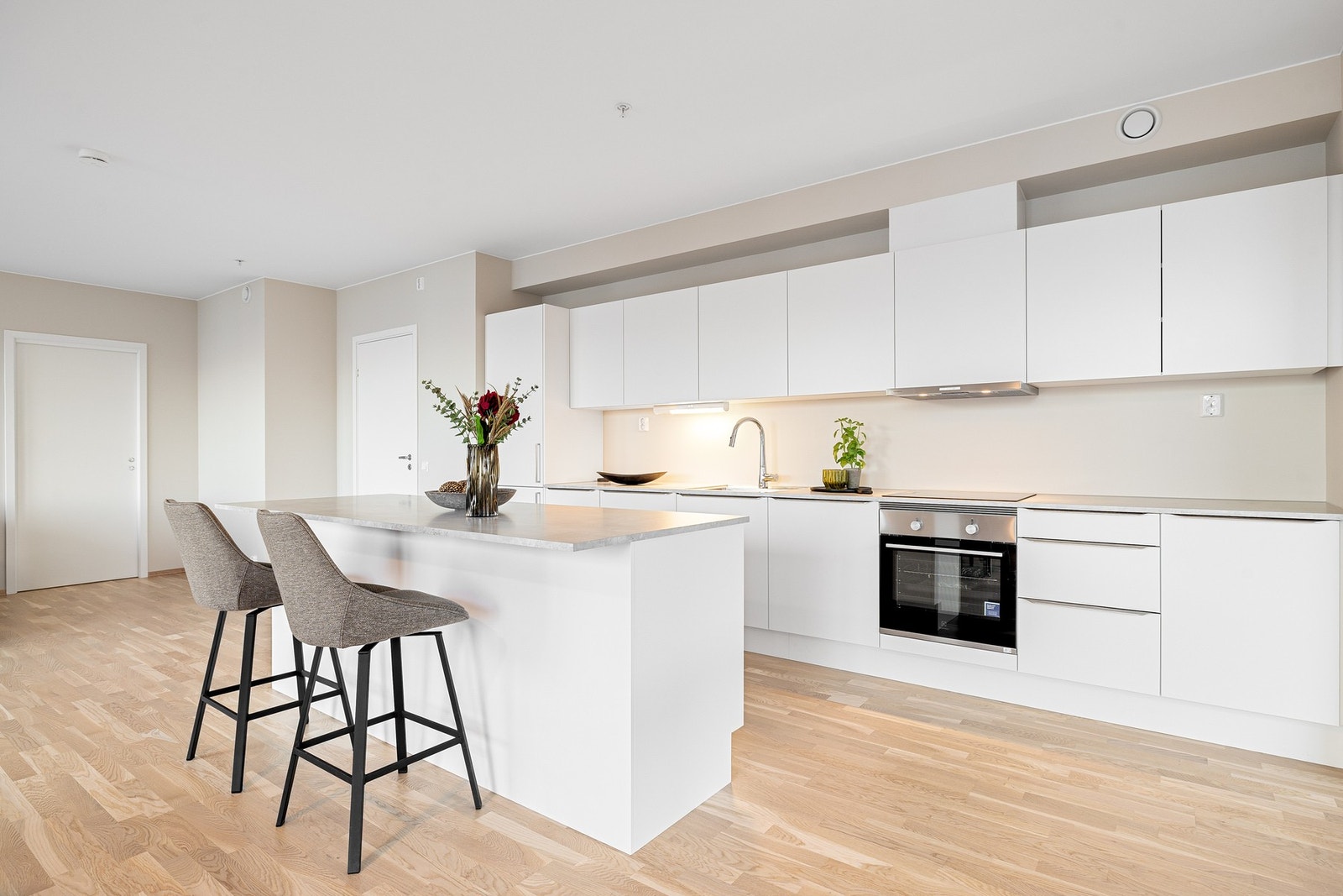 Lyst og moderne kjøkken med glatte kjøkkenfronter. Galleribilde