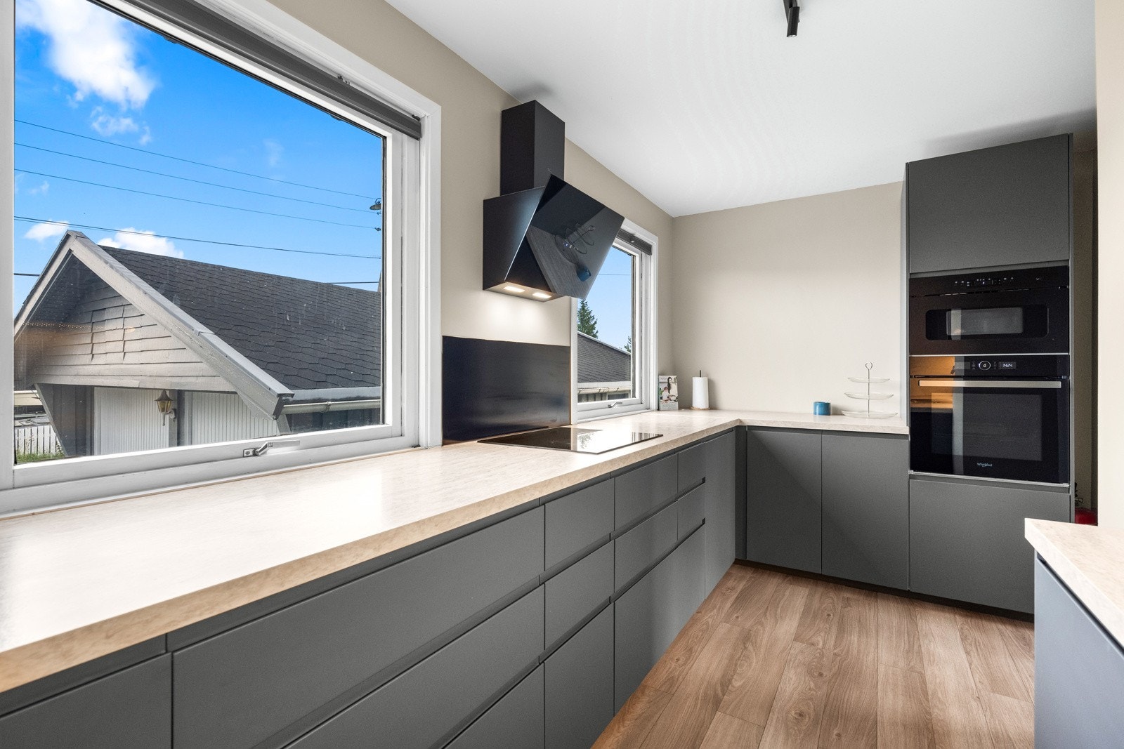 Integrerte hvitevarer og stilfull platetopp med sprutplate av laminat. Galleribilde