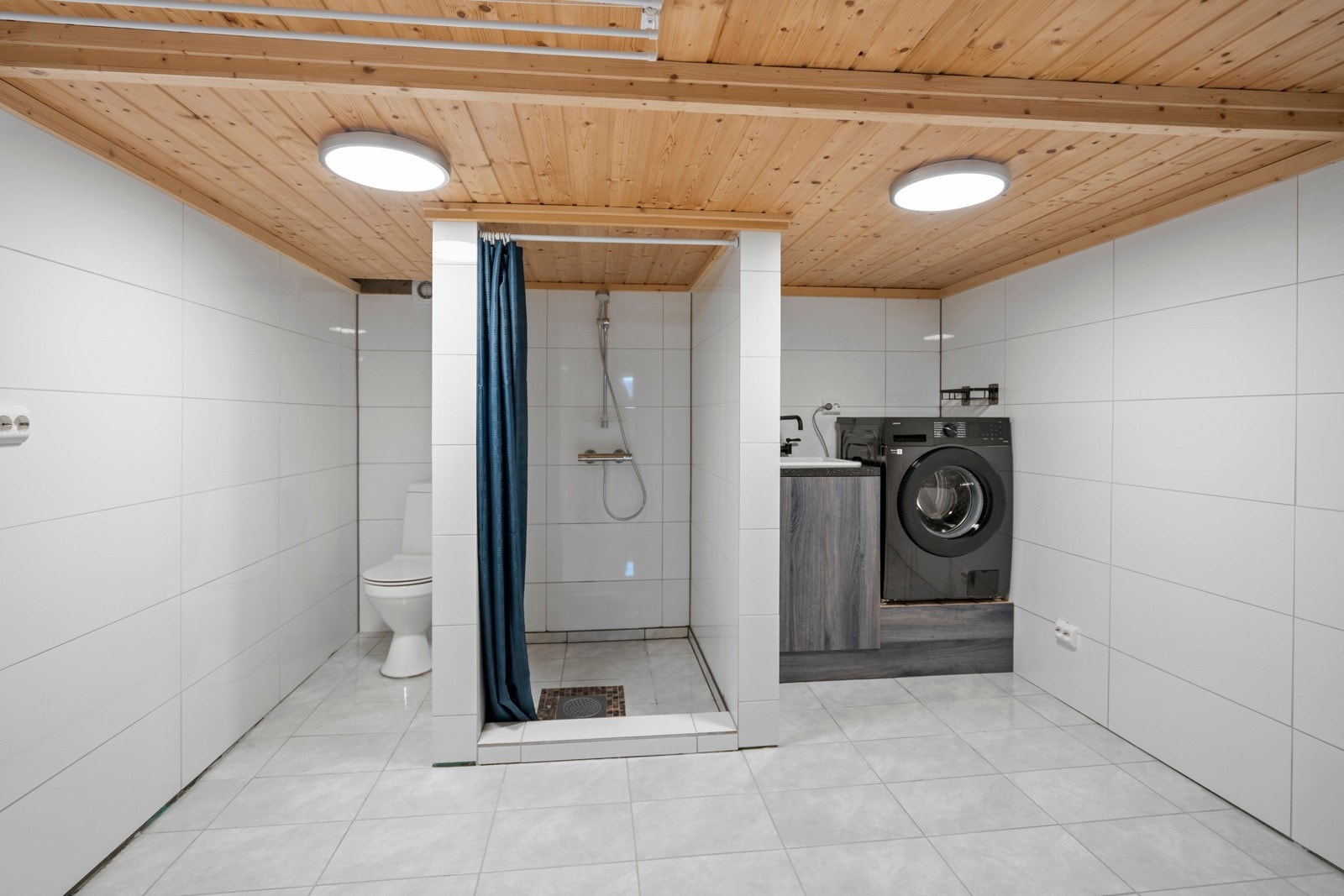 Vaskerom/bad i kjelleren er helfliset med dusjnisje, toalett og opplegg for vaskemaskin. Himlingen i dette rommet er noe lav. Galleribilde