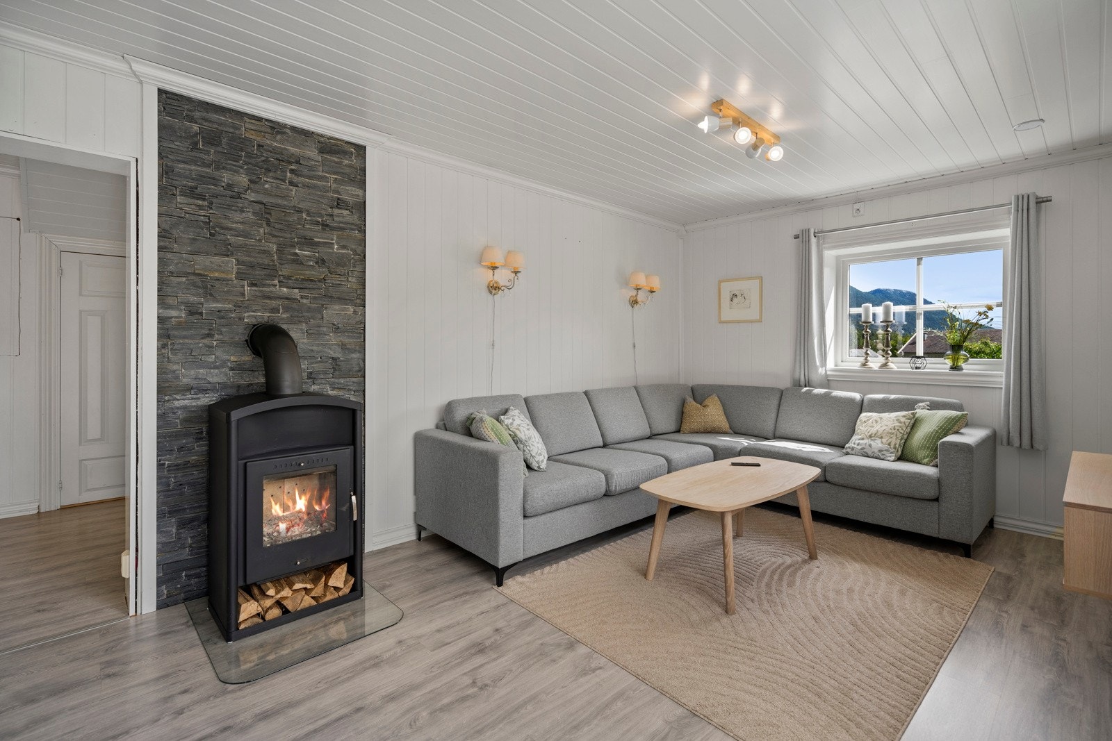 Boligens stue har godt med lysinnslipp. Det er peisovn og varmepumpe i stua. Galleribilde