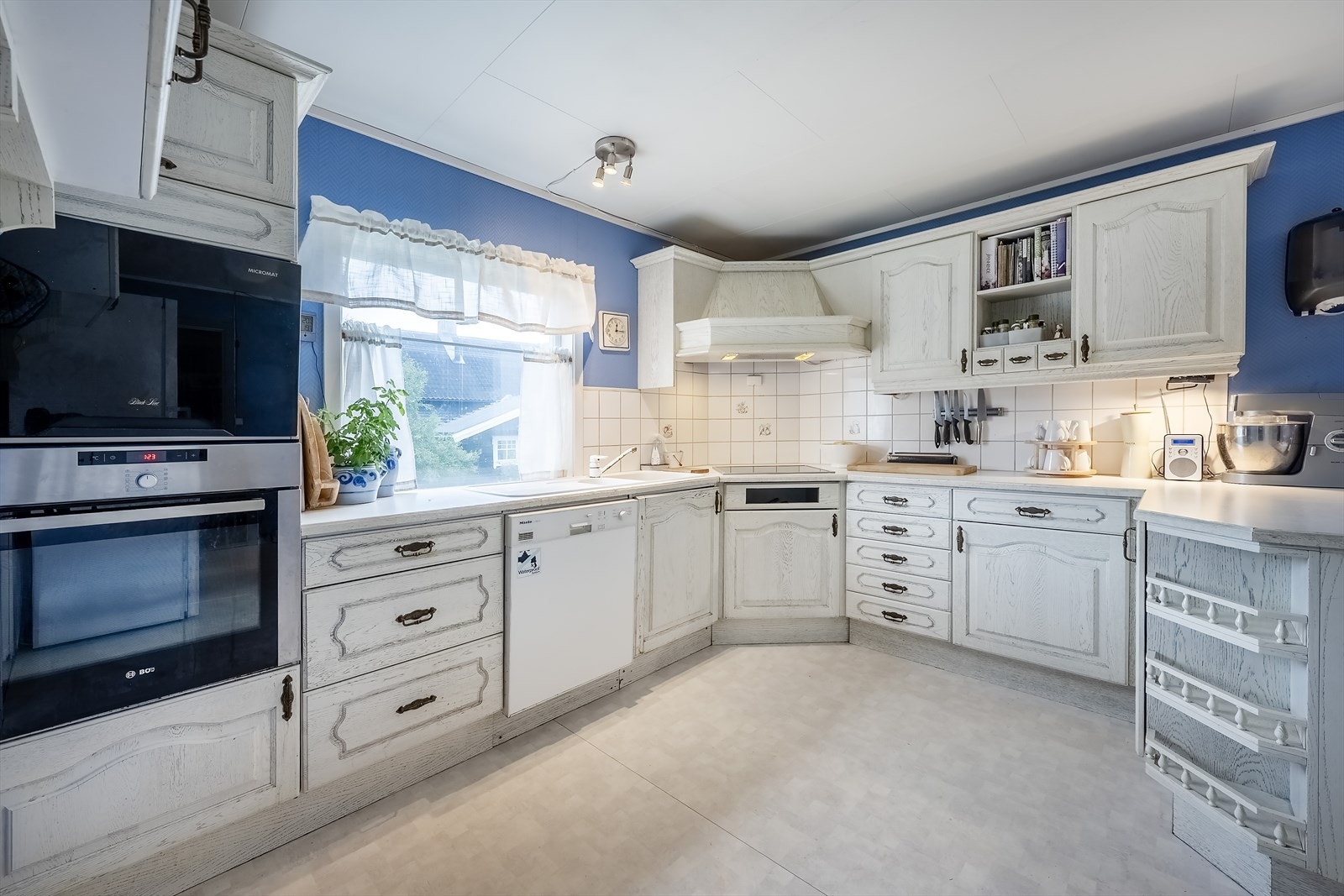 Kjøkkenet har innredning med integrerte hvitevarer Galleribilde