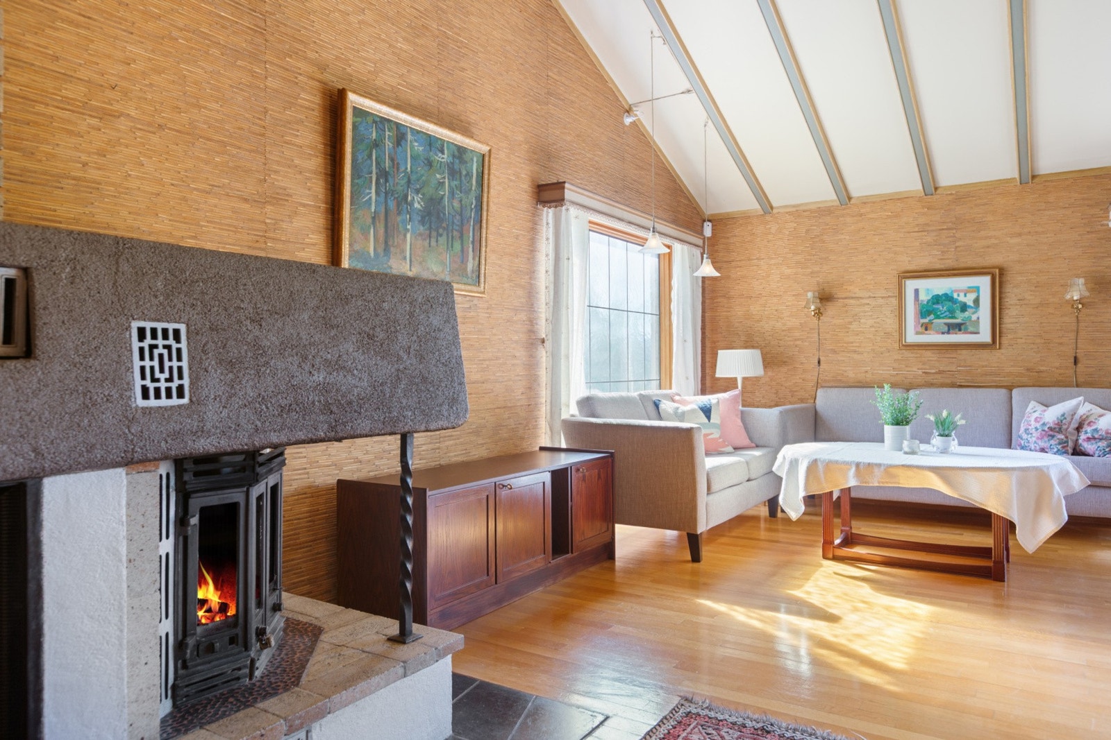 Stuen har god takhøyde, som gir en god og luftig romfølelse. Her er veggene kledd med Biritapet - håndlaget norsk stråtapet. Galleribilde