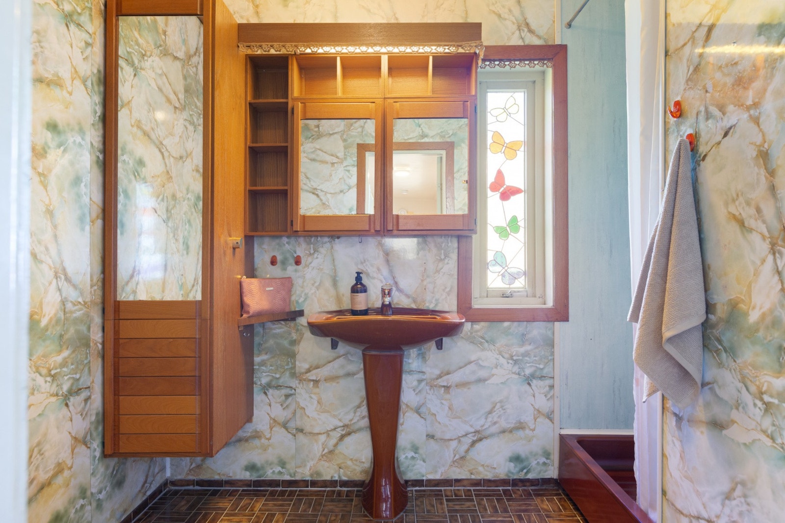 Badet har baderomsplater på vegg og fliser på gulv. Servant, skapinnredning, toalett og dusj med forheng. Galleribilde