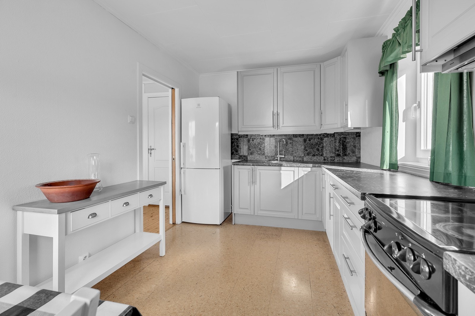 Lyse fronter, mørk benkeplate og vindu som slipper inn dagslys. Galleribilde