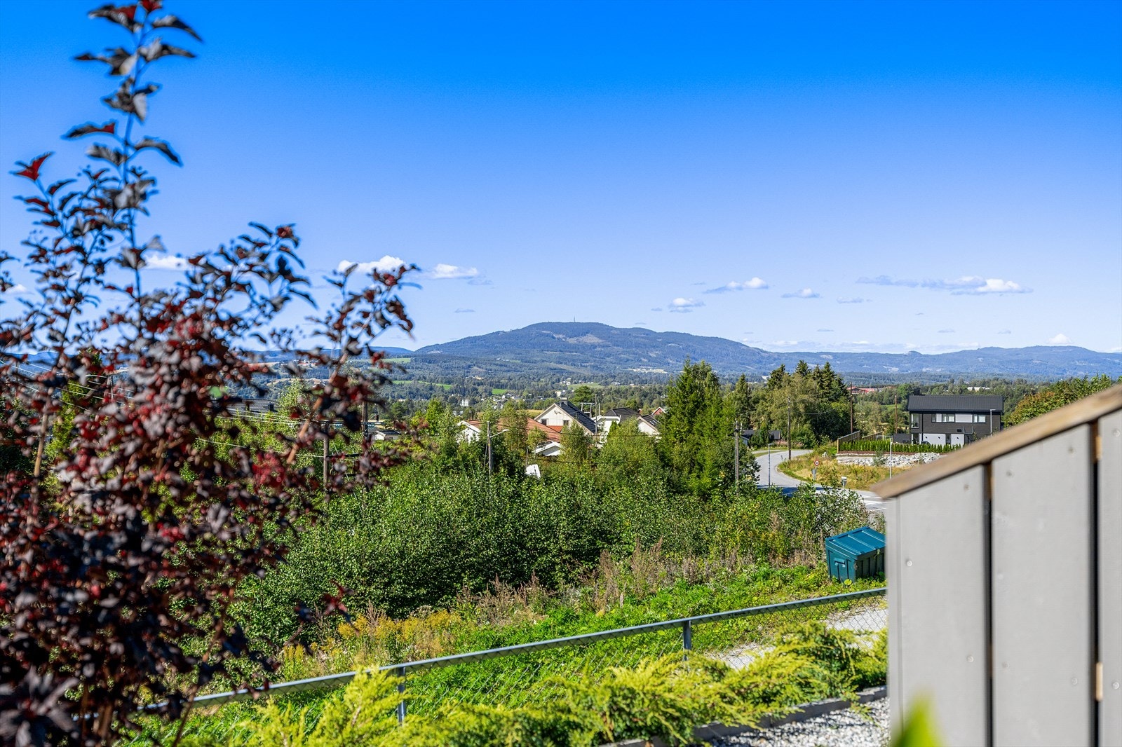 Utsikt. Gjerde utenfor terrasse og hage. Galleribilde