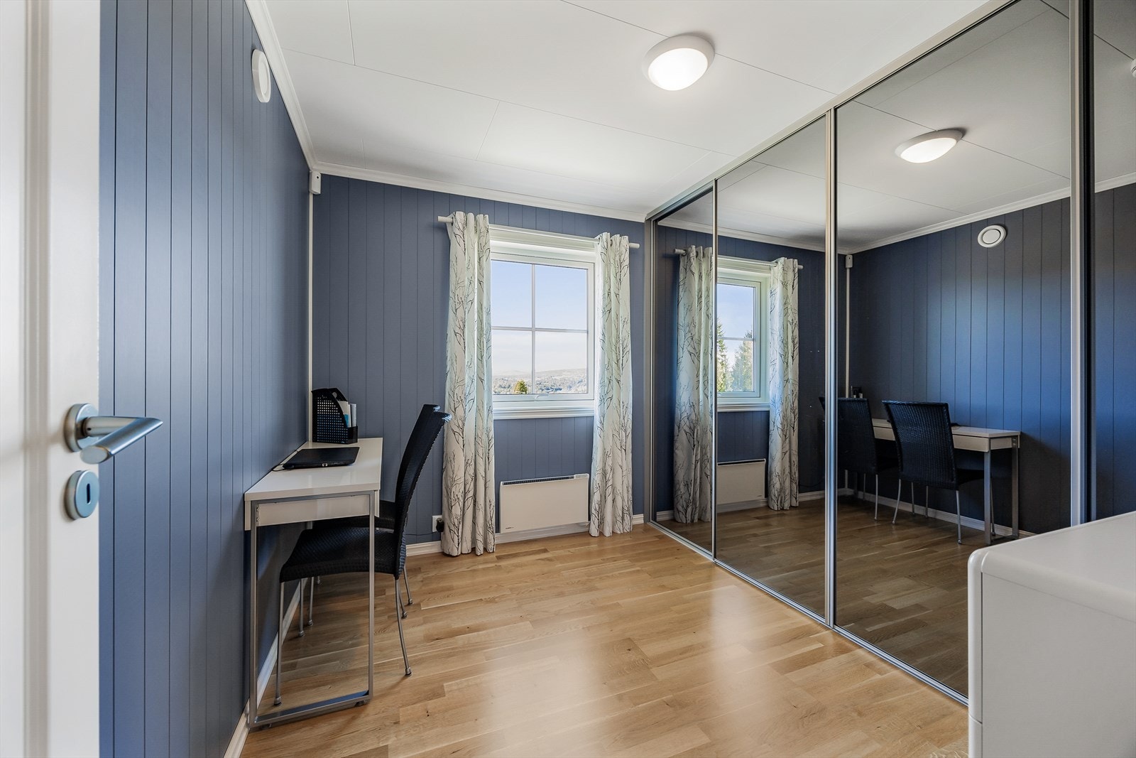 Soverom med stor skyvedørsgarderobe. Kanskje brukes som kontor eller walk-in closet? Galleribilde