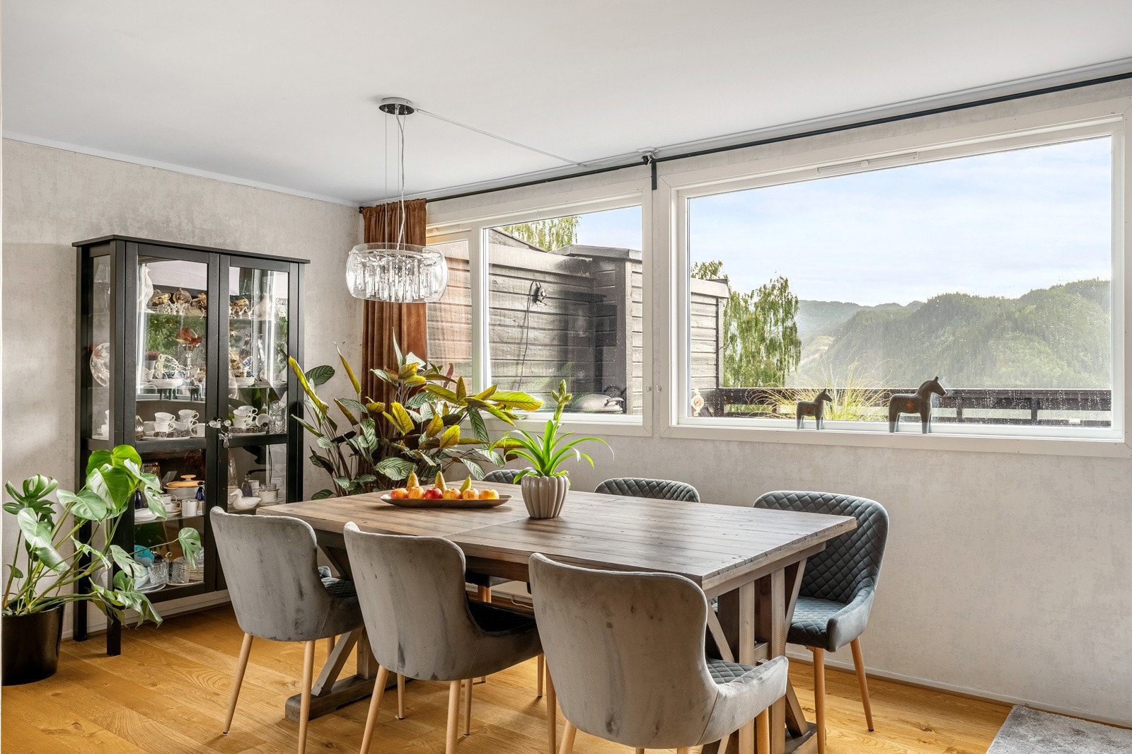 Stuen preges av store vindusflater, parkett på gulv og moderne fargevalg på veggene med ny tapet lagt i 2024. Galleribilde