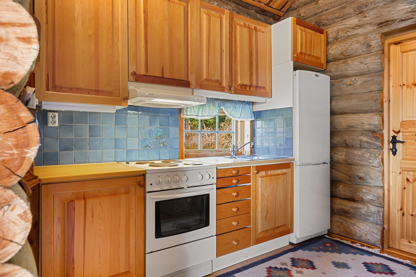 Kjøkkeninnredning med profilerte lakkerte fronter og laminat benkeplate. Galleribilde