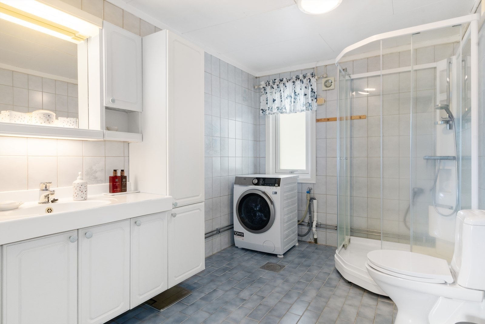 Romslig bad med fliser på gulv og vegger. Galleribilde