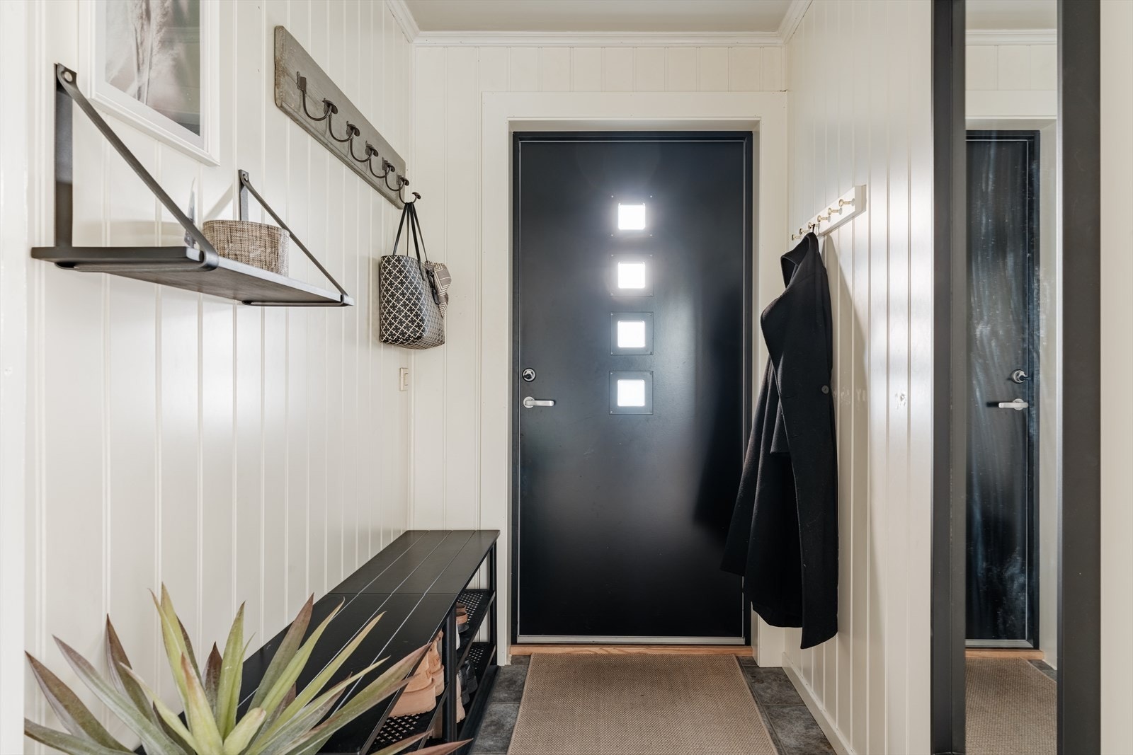 Rommet byr på praktiske løsninger for oppbevaring og god plass til å henge fra seg yttertøy og sko. Galleribilde