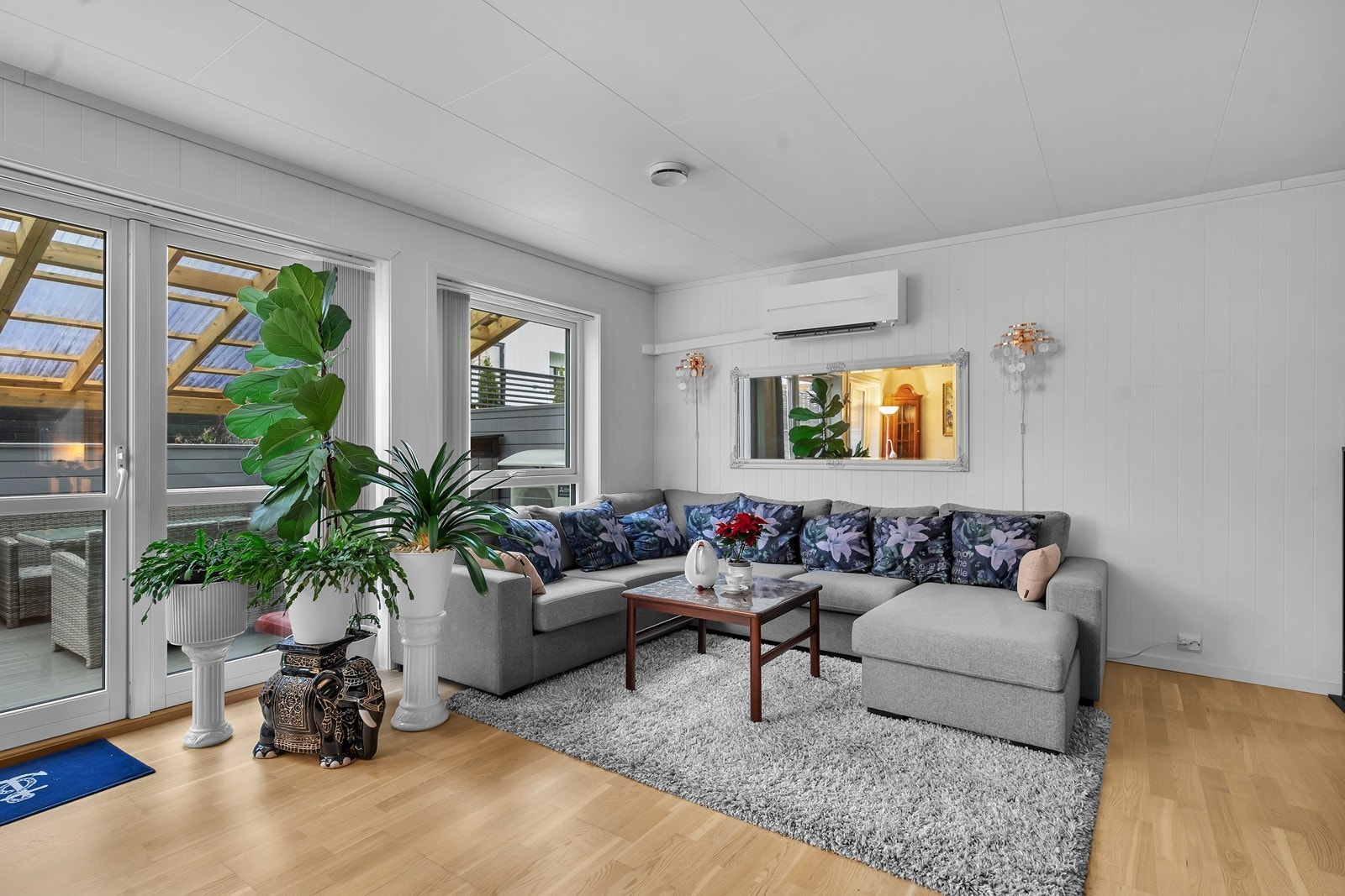 Fra stuen er det direkte utgang til et av bolig ens flere uteområder - et hyggelig sted å nyte solen. Galleribilde