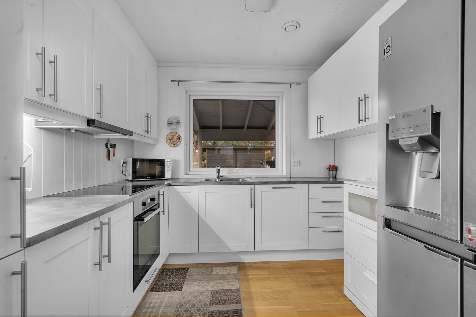 Lyst og pent kjøkken med mye skap- og benkeplass. Galleribilde