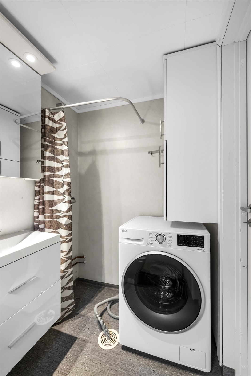 Videre er det dusjhjørne med forheng og opplegg for vaskemaskin. Galleribilde