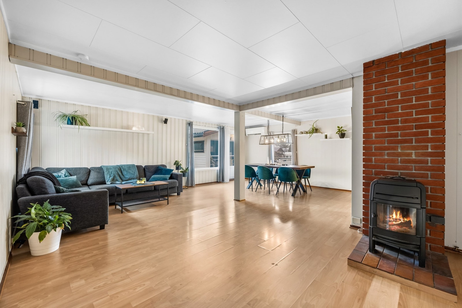 Stuen er boligens naturlige samlingspunkt - med lyse panelvegger og laminat på gulvet. Peis gir både varme og kos på kalde dager. Galleribilde