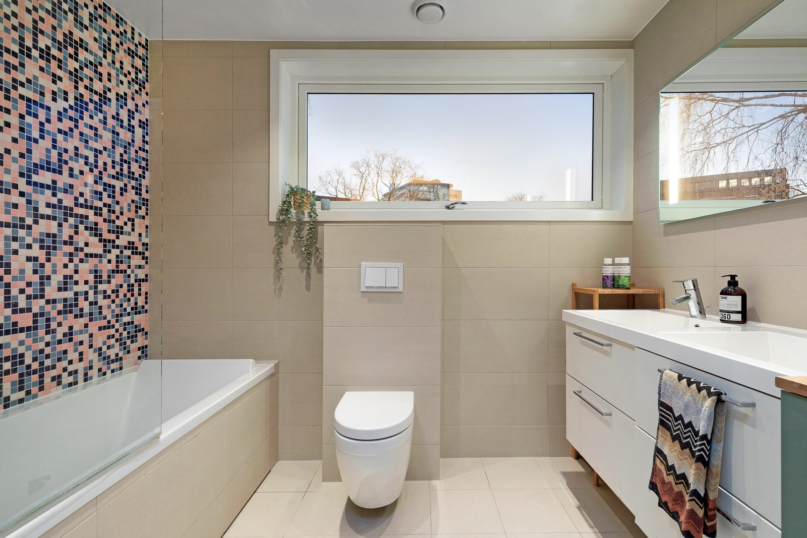 Pent baderom ned vegghengt wc, badekar og baderomsmøbler Galleribilde