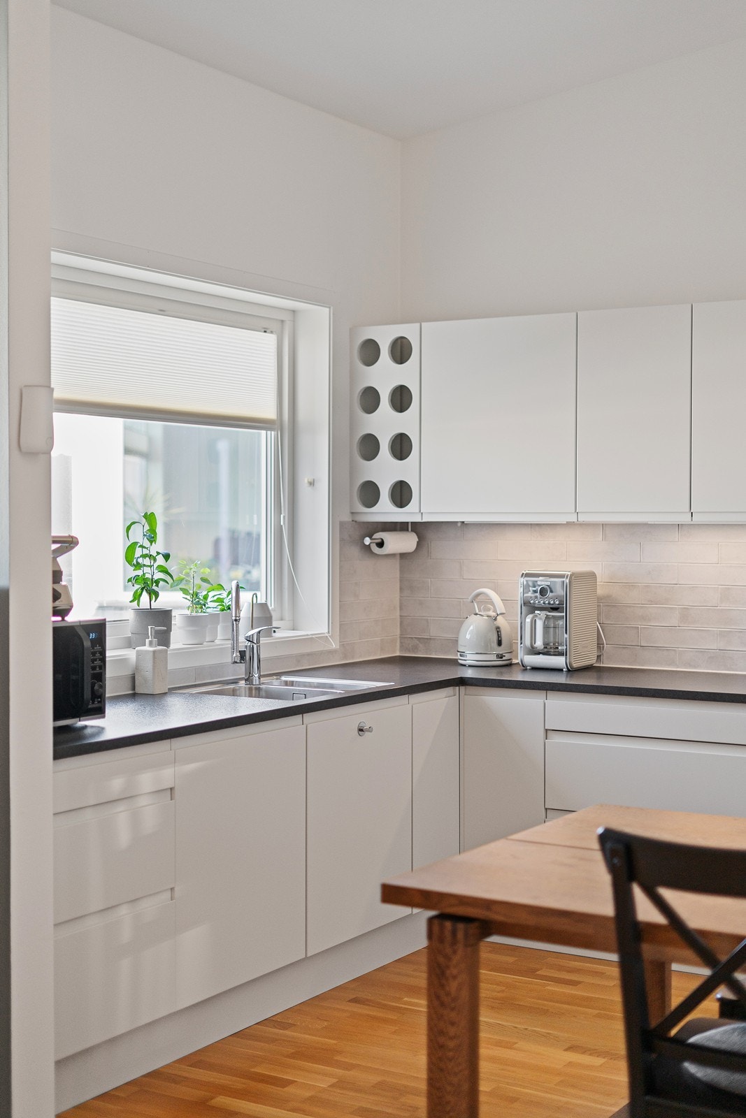 Delikat og moderne. Lyse håndtakfrie fronter. Mørk laminatbenkeplate som gir en fin kontrast til den ellers lyse innredningen. Galleribilde