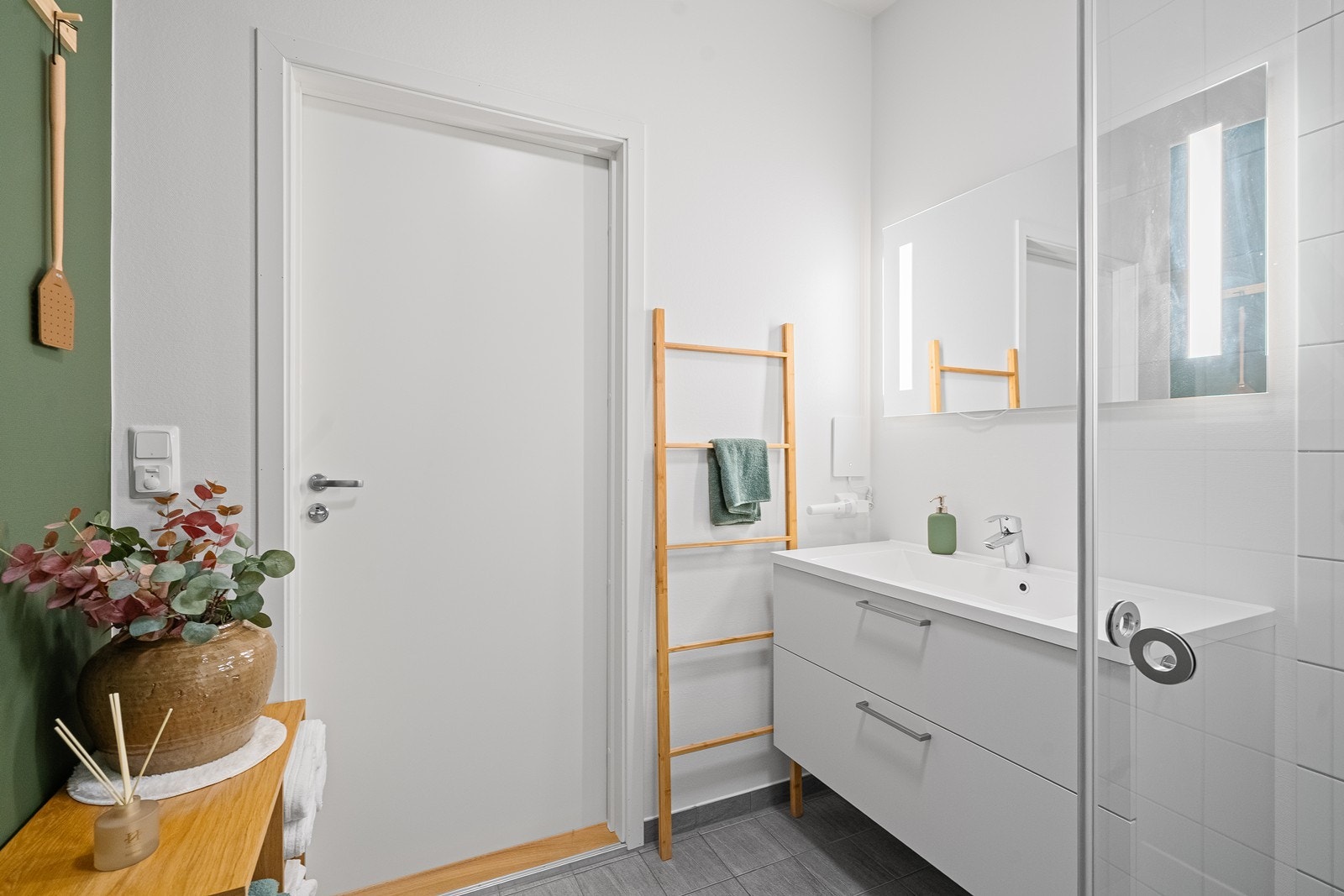 Badet i 1. etasje er funksjonelt innredet med dusj, toalett og nedfelt vask i seksjon, som gir et ryddig og praktisk uttrykk. Galleribilde