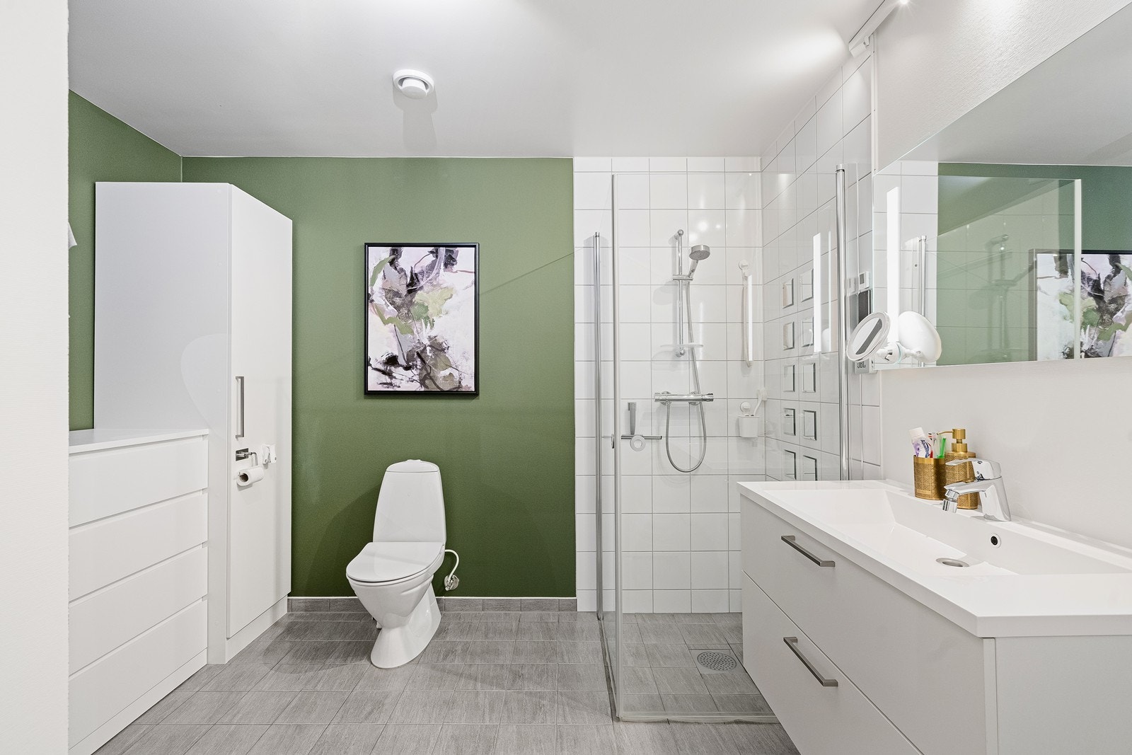 Det kombinerte bad- og vaskerommet i underetasjen er funksjonelt innredet med dusj, toalett og vask i innredning, som gir en praktisk og ryddig løsning. Galleribilde