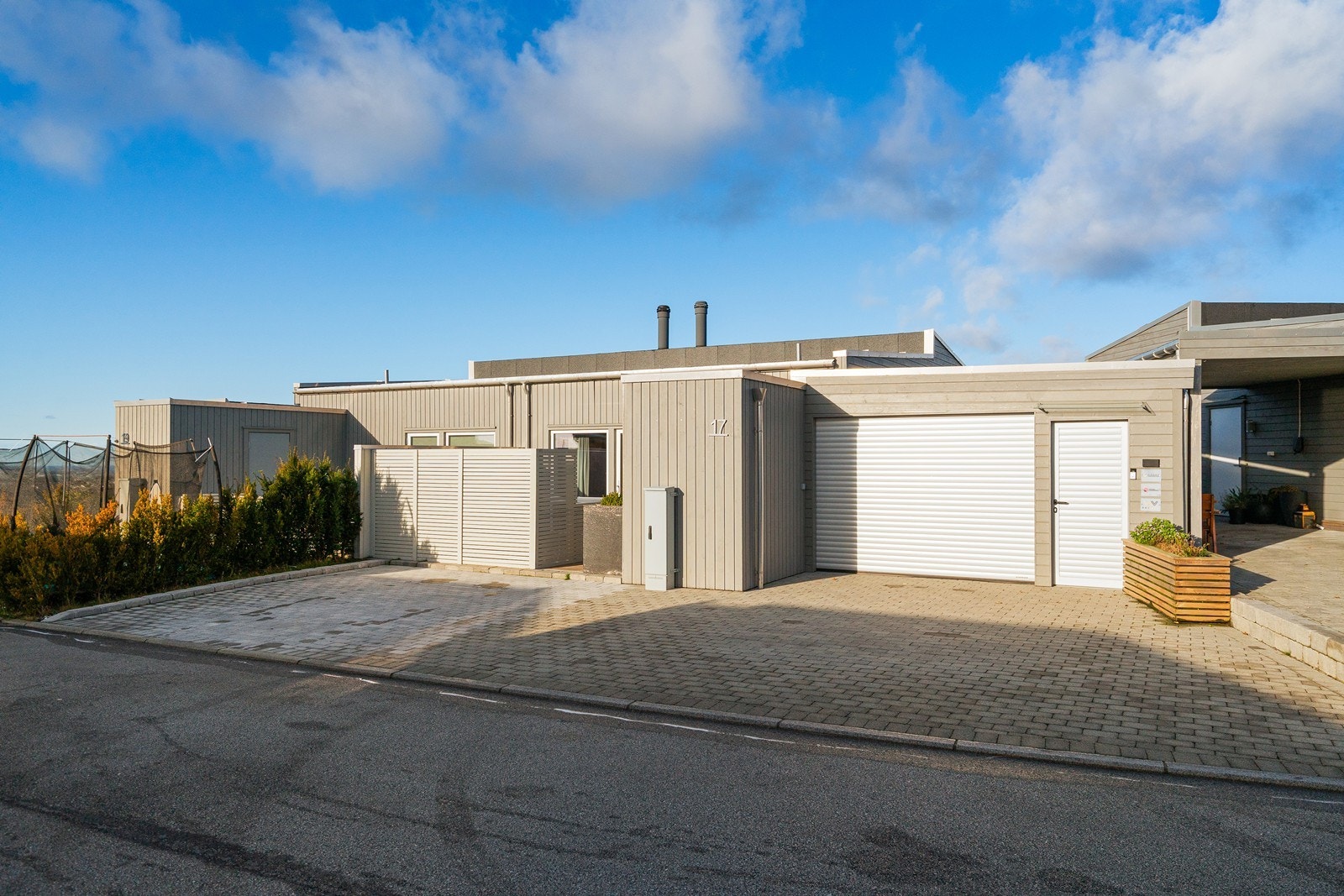 Gårdsrommet er innbydende og har god plass til både parkering og garasje, med praktisk adkomst til boligen. Galleribilde