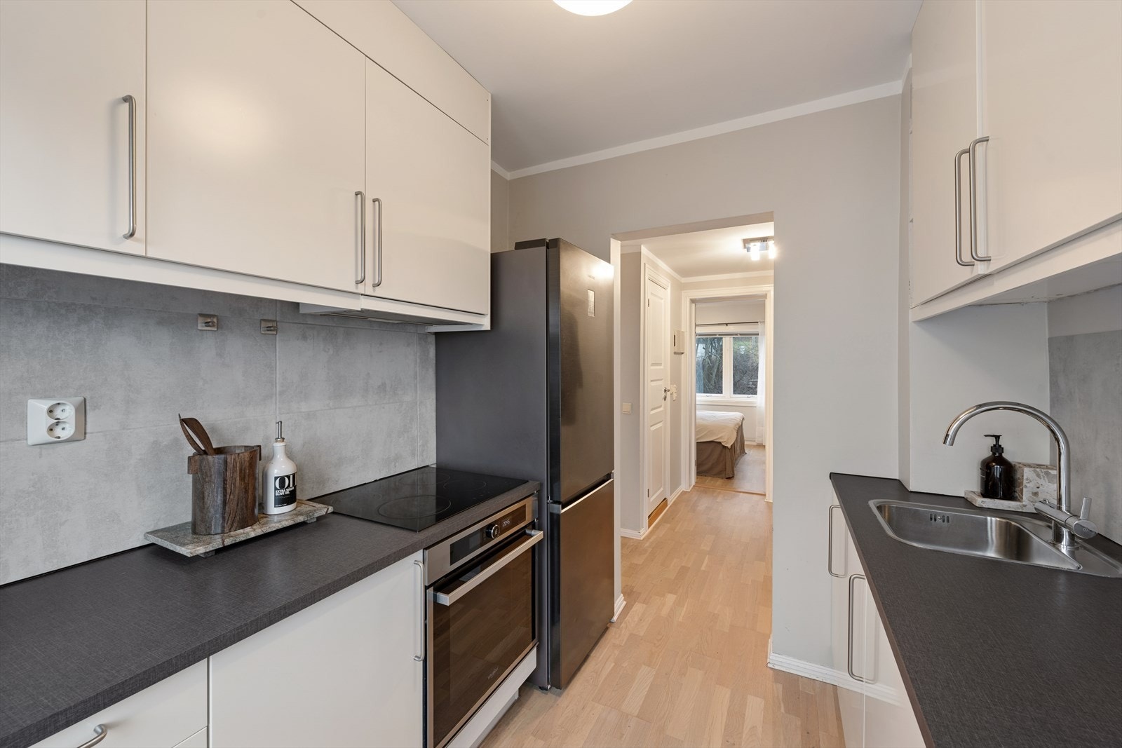 Integrert platetopp, stekeovn, oppvaskmaskin og frittstående kjøle-/fryseskap. Galleribilde