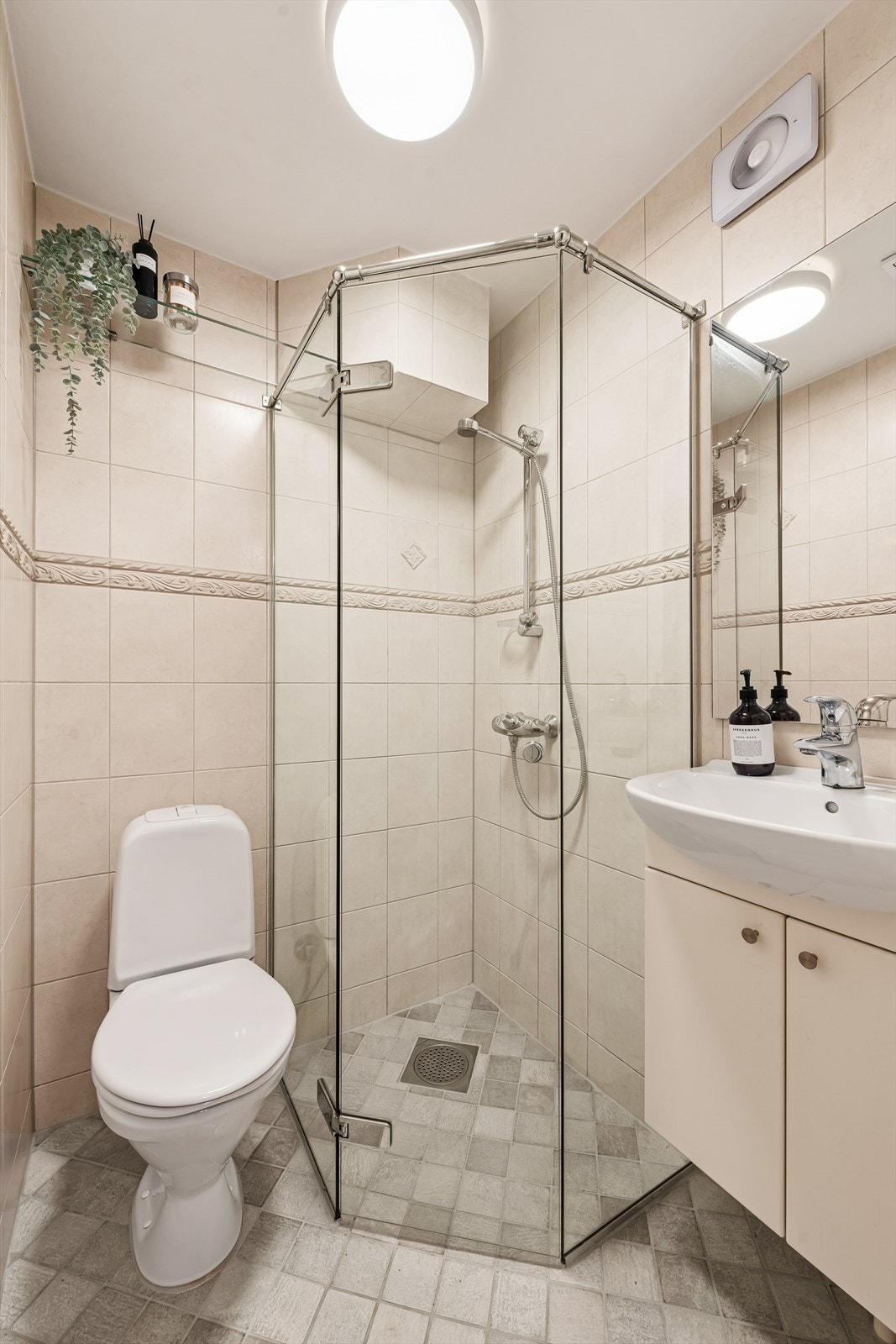 Badet er flislagt og oppført i 2006, med en tidløs og funksjonell utforming. Rommet er innredet med stående toalett, dusjhjørne samt servant med praktisk underskap som gir god oppbevaringsplass. Galleribilde