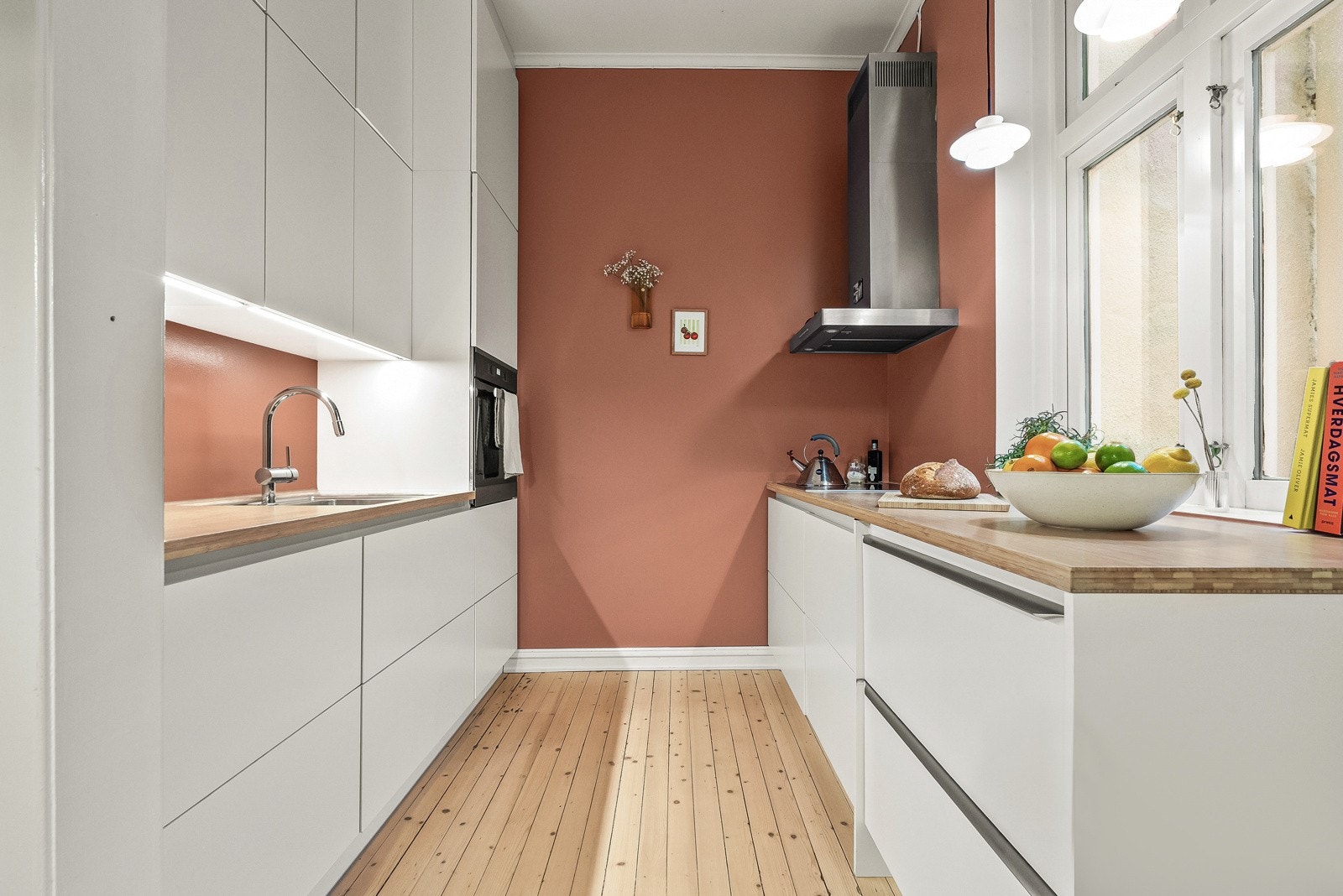 Lekker kjøkkenløsning med slette fronter og push-open skuffer. Overskap med benkebelysning og benkeskap på to vegger Galleribilde