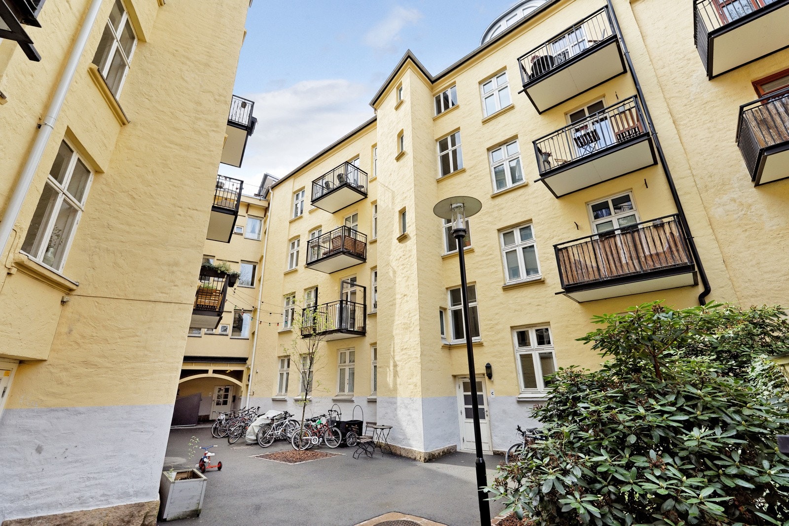 Pent opparbeidet bakgård med gressplen, lekeplass og hyggelige sittegrupper. Galleribilde