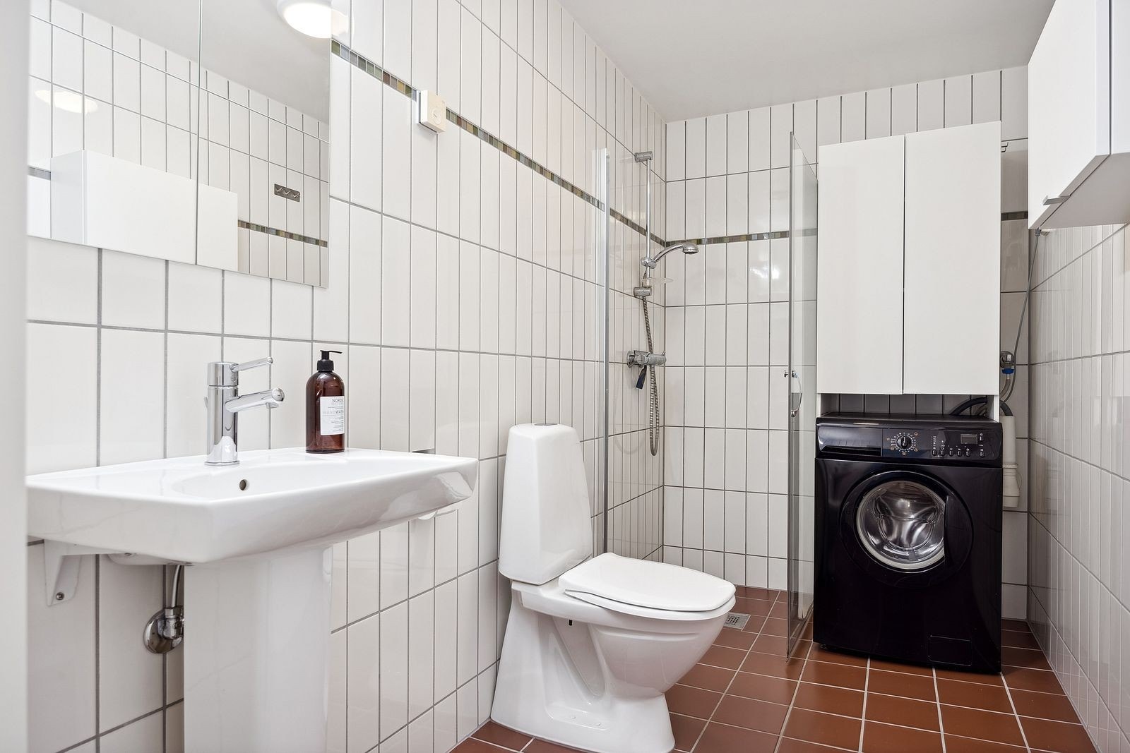 Pent flislagt bad med vaskemaskin, innfellbare dusjvegger, wc, servant og speilskap. Varme i gulv. Galleribilde