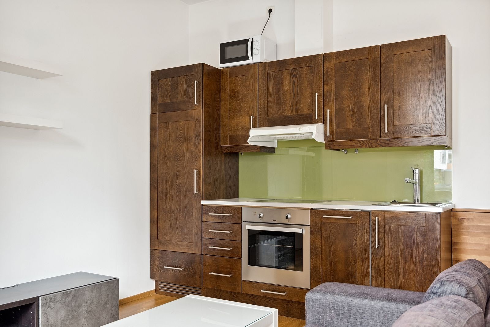 Pent kjøkken med integrert kjøleskap, oppvaskmaskin og komfyr. Galleribilde