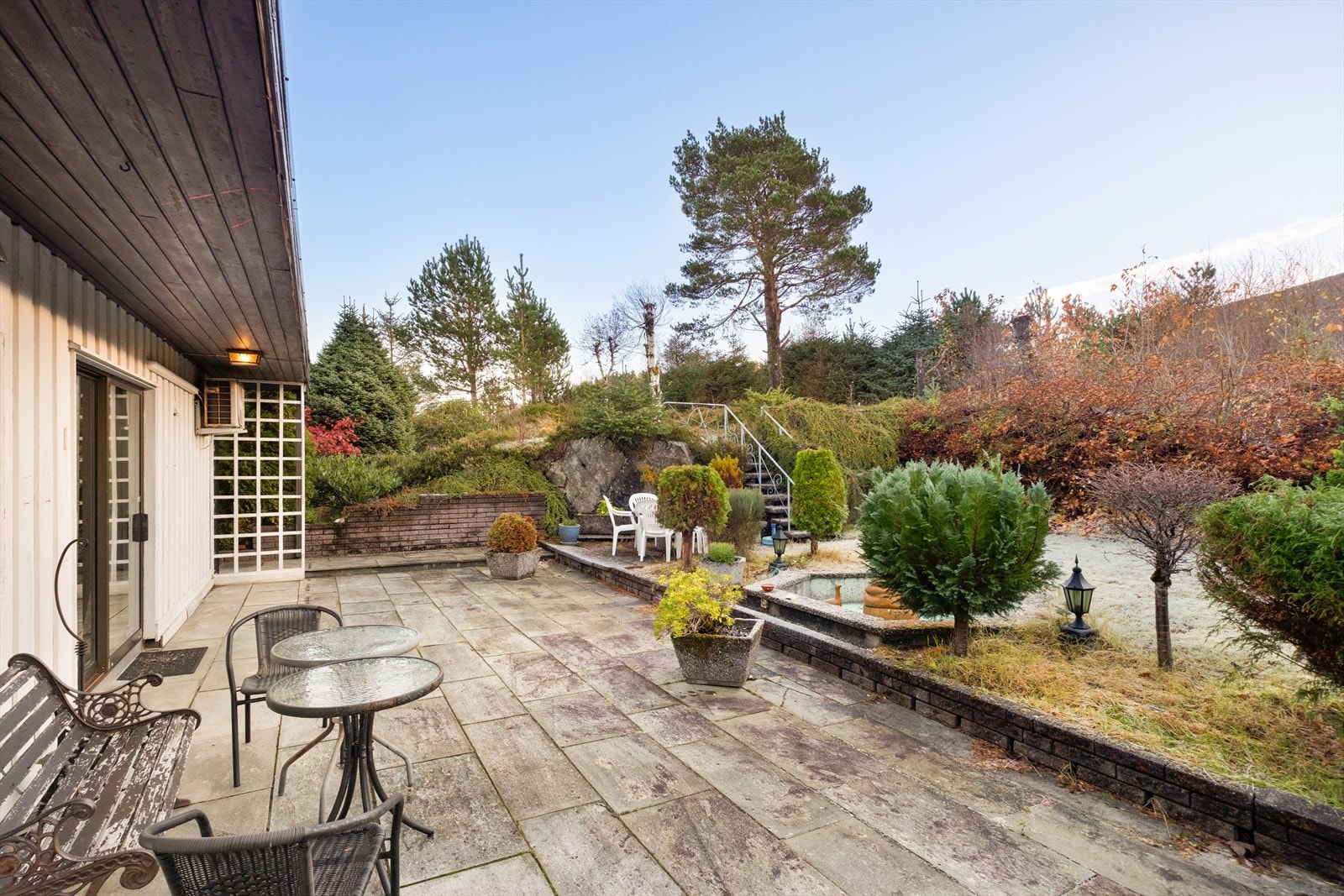 Terrasse med skiferstein og beplantning gir en privat utendørs oppholdsplass. Galleribilde