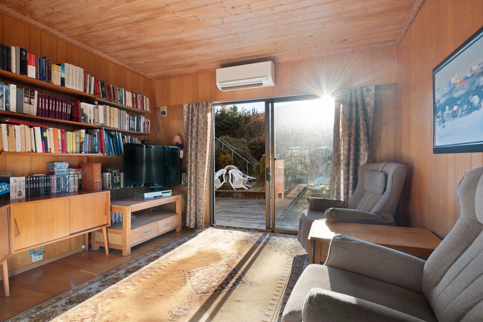 Utgang til terrasse fra tv-stuen gir enkel tilgang til uteområdet, med varmepumpe for komfort. Galleribilde