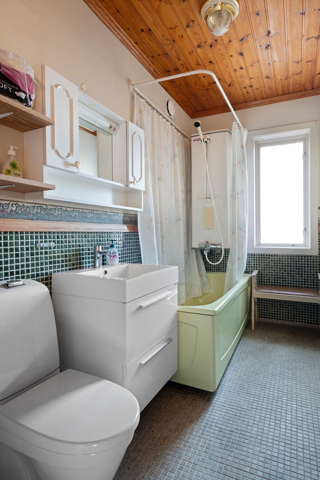 Badet i hovedetasjen har flislagt gulv og vegger, samt panel i himlingen. Toalettet og baderomsinnredningen er av nyere dato Galleribilde