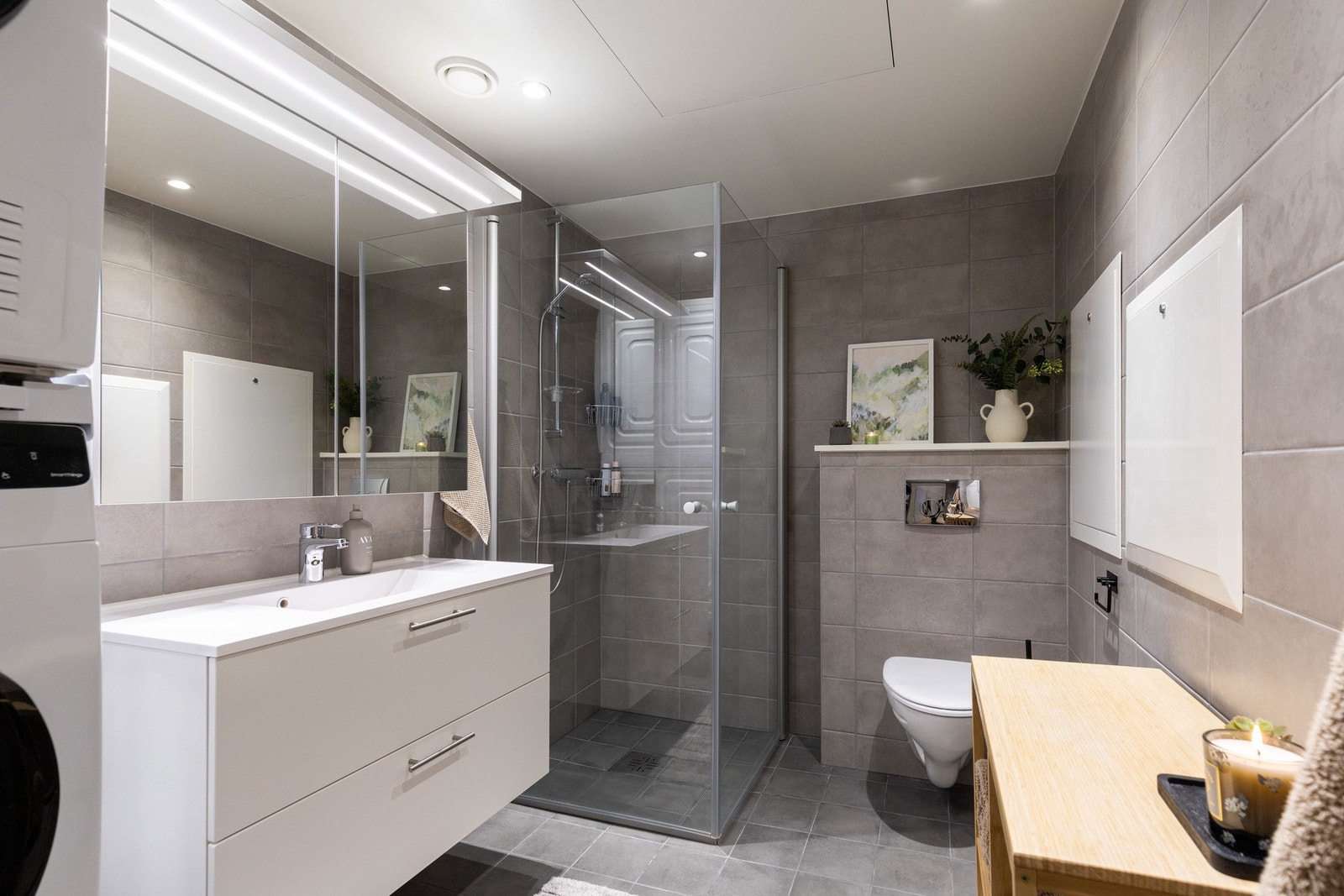 Badet fremstår moderne og tidløst med fliser på gulv og vegger samt elektriske varmekabler i gulv. Galleribilde