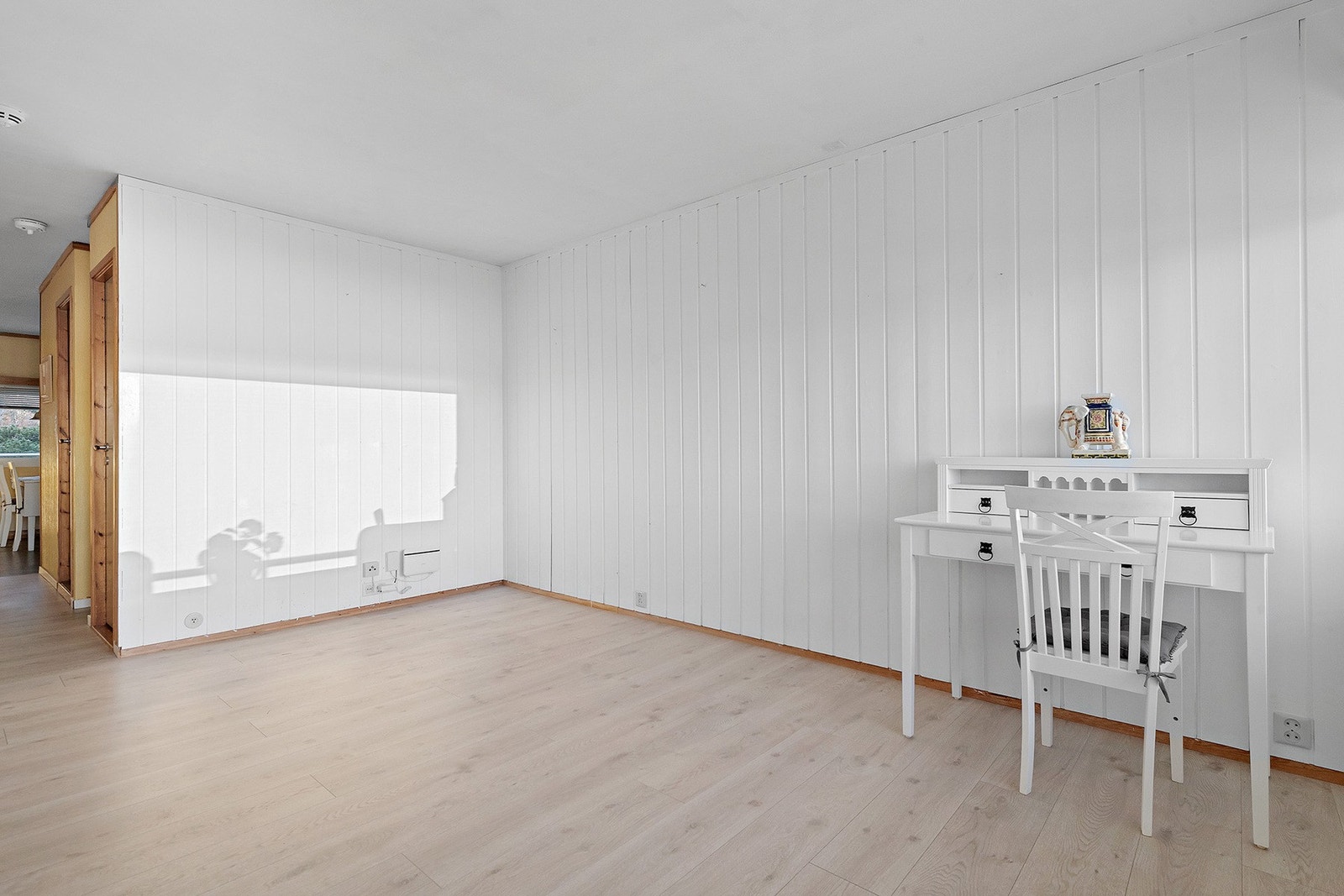 Gulv har laminat på stue og belegg på kjøkkenet. Stuen er malt i en lys farge med mye lysinnslipp fra de store vindusflatene. Galleribilde