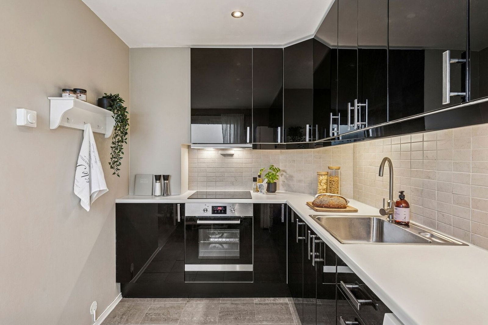 Innredningen har sorte høyglans fronter og laminat benkeplate. Ventilator i stål fra 2025 med kullfilter og komfyrvakt fra 2023. Galleribilde