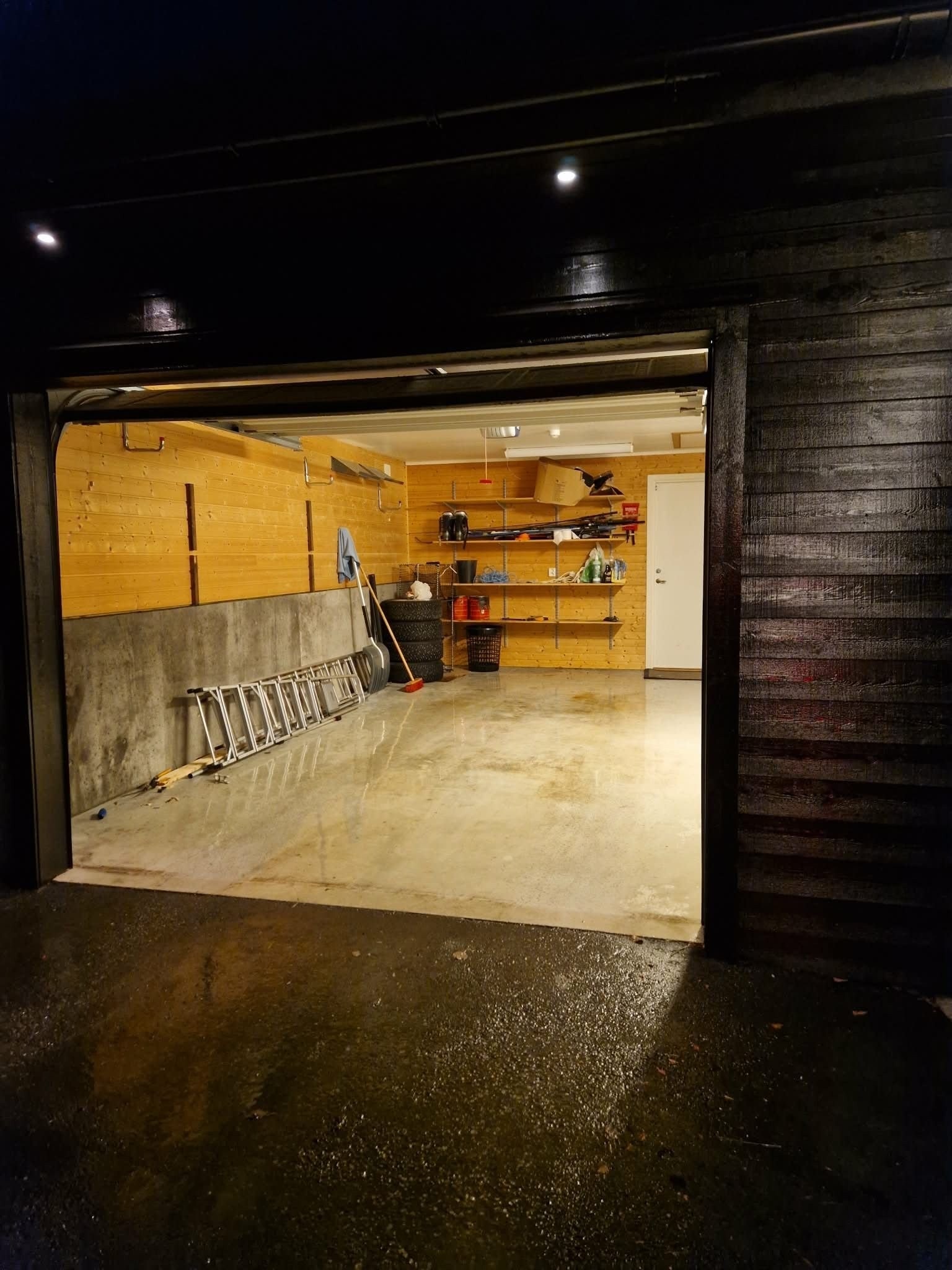 Romslig garasje med elbillader og dør til sportsbod i bakkant. Inngang fra garasjen til vaskerom. Galleribilde